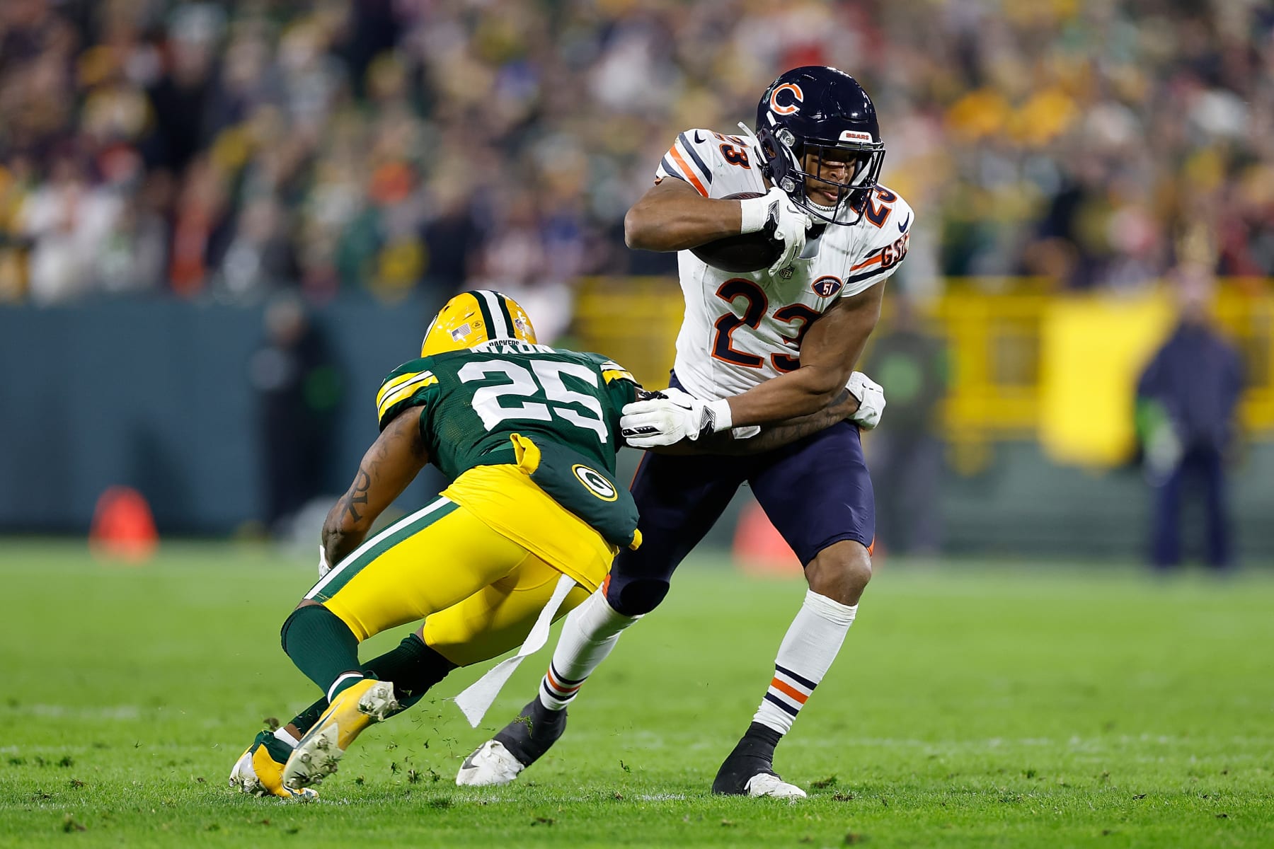 GREEN BAY, WISCONSIN - JANUARY 07: Roschon Johnson #23 of the Chicago Bears avoids the tackle of Keisean Nixon #25 of the Green Bay Packers at Lambeau Field on January 07, 2024 in Green Bay, Wisconsin. (Photo by John Fisher/Getty Images)