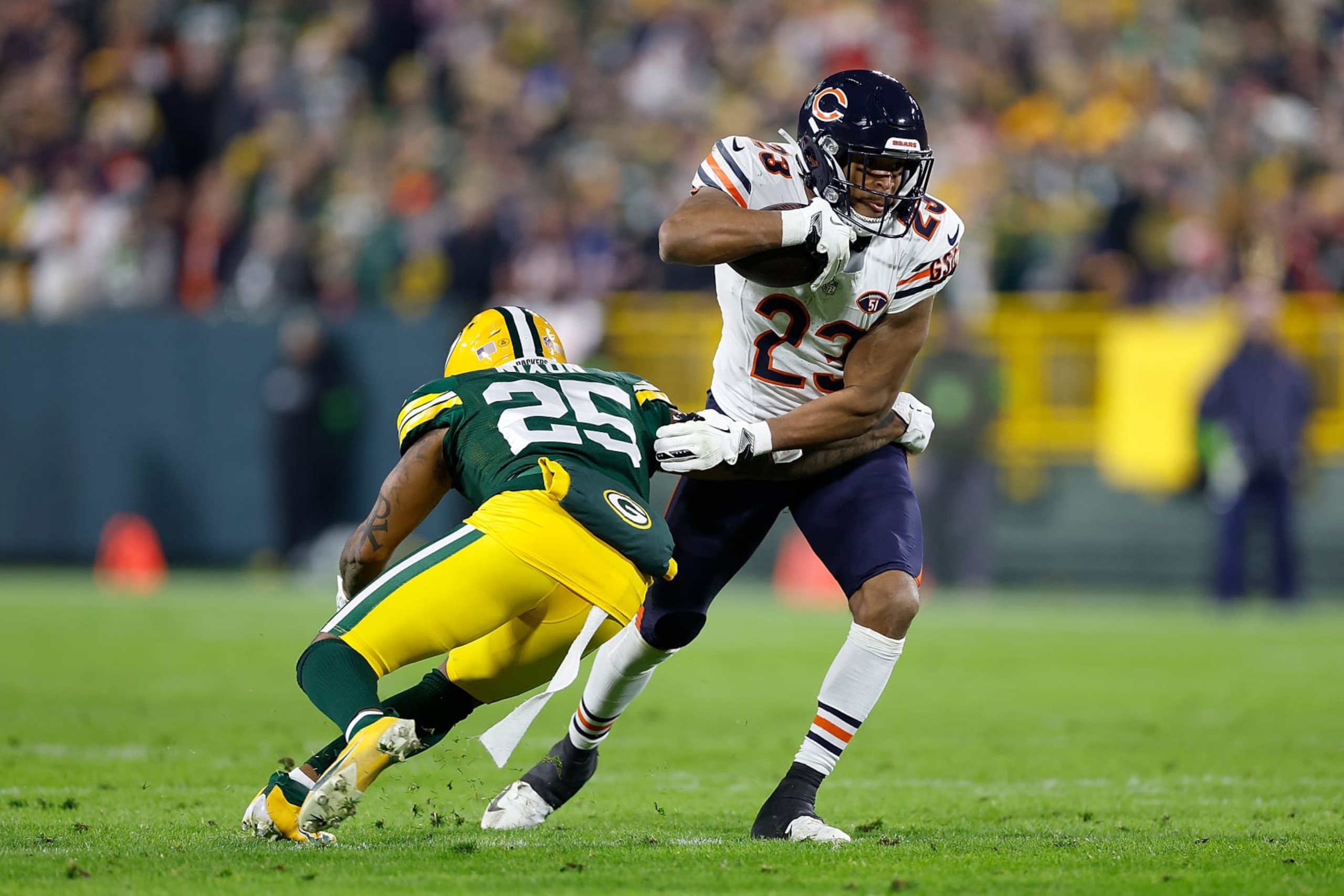 GREEN BAY, WISCONSIN - JANUARY 07: Roschon Johnson #23 of the Chicago Bears avoids the tackle of Keisean Nixon #25 of the Green Bay Packers at Lambeau Field on January 07, 2024 in Green Bay, Wisconsin. (Photo by John Fisher/Getty Images)