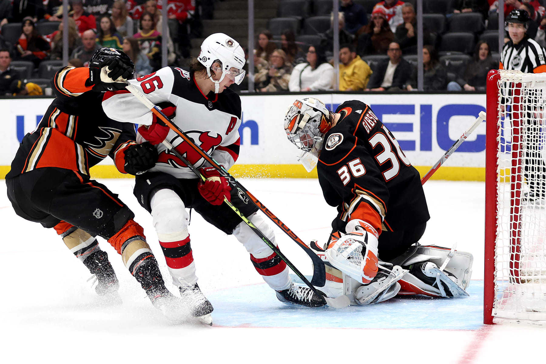 ANAHEIM, CALIFORNIA - JANUARY 13: Cam Fowler #4 and John Gibson #36 of the Anaheim Ducks are unable to defend against a goal by Jack Hughes #86 of the New Jersey Devils during the third period of a game at Honda Center on January 13, 2023 in Anaheim, California. (Photo by Sean M. Haffey/Getty Images)
