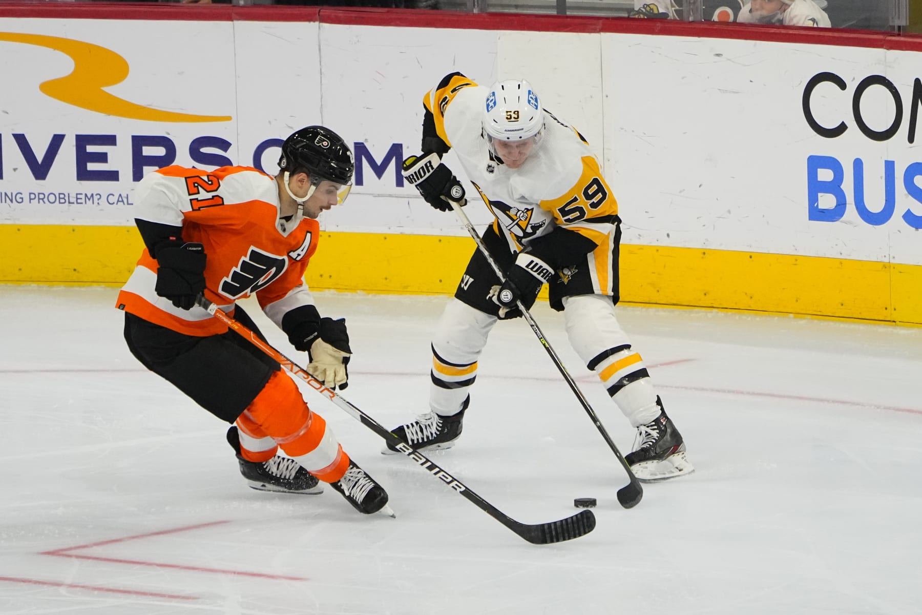 PHILADELPHIA, PA - JANUARY 06: Philadelphia Flyers Left Wing Scott Laughton (21) and Pittsburgh Penguins Left Wing Jake Guentzel (59) battle for the puck during the third period of the National Hockey League game between the Pittsburgh Penguins and the Philadelphia Flyers on January 6, 2022, at the Wells Fargo Center in Philadelphia, PA.  (Photo by Gregory Fisher/Icon Sportswire via Getty Images)