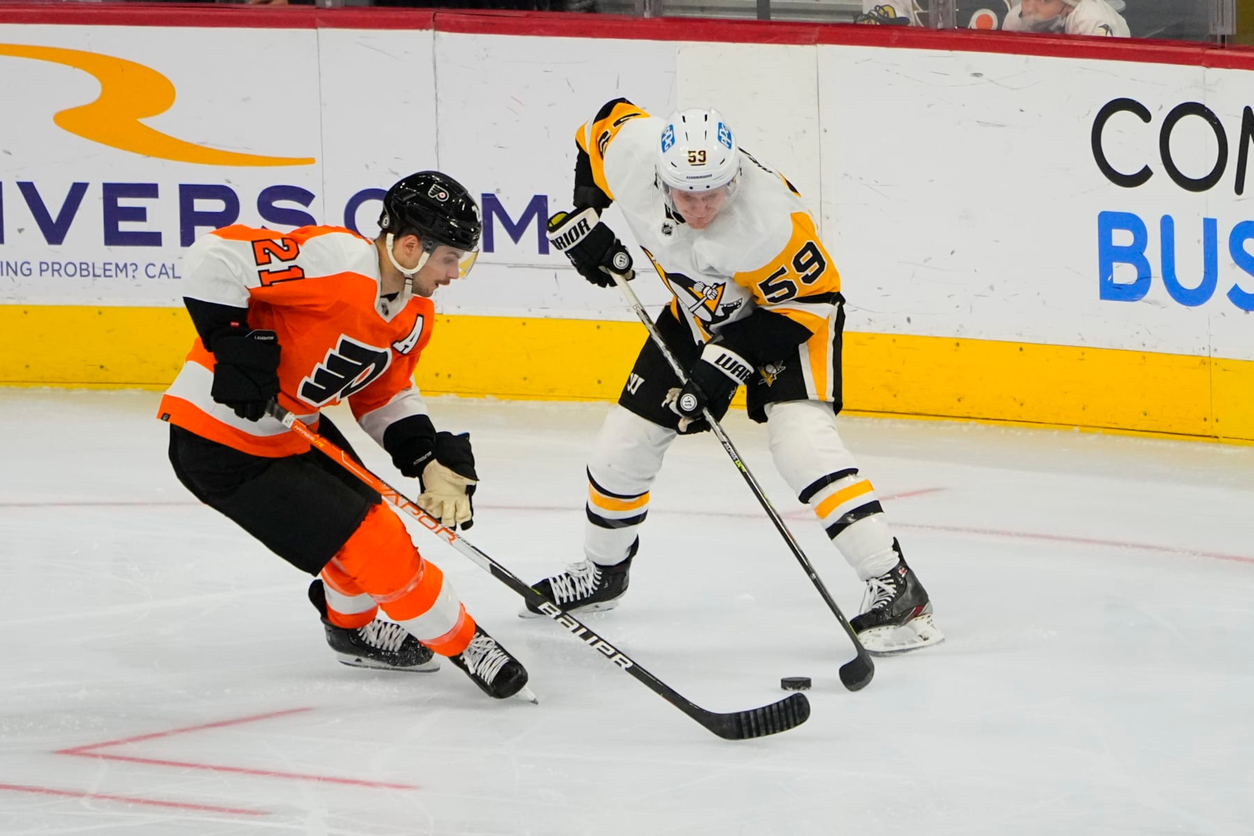 PHILADELPHIA, PA - JANUARY 06: Philadelphia Flyers Left Wing Scott Laughton (21) and Pittsburgh Penguins Left Wing Jake Guentzel (59) battle for the puck during the third period of the National Hockey League game between the Pittsburgh Penguins and the Philadelphia Flyers on January 6, 2022, at the Wells Fargo Center in Philadelphia, PA.  (Photo by Gregory Fisher/Icon Sportswire via Getty Images)