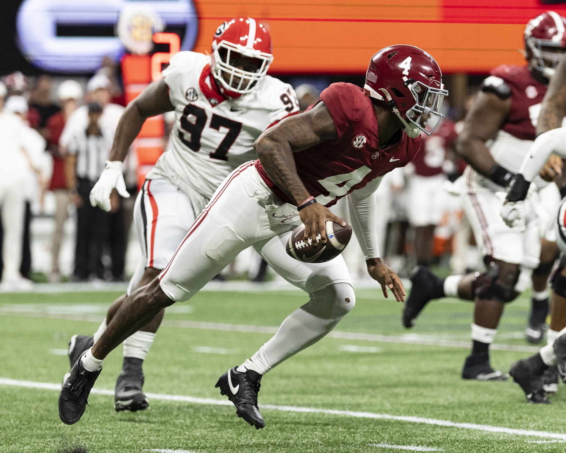 Jalen Milroe of the Alabama Crimson Tide avoids the Georgia pass rush.