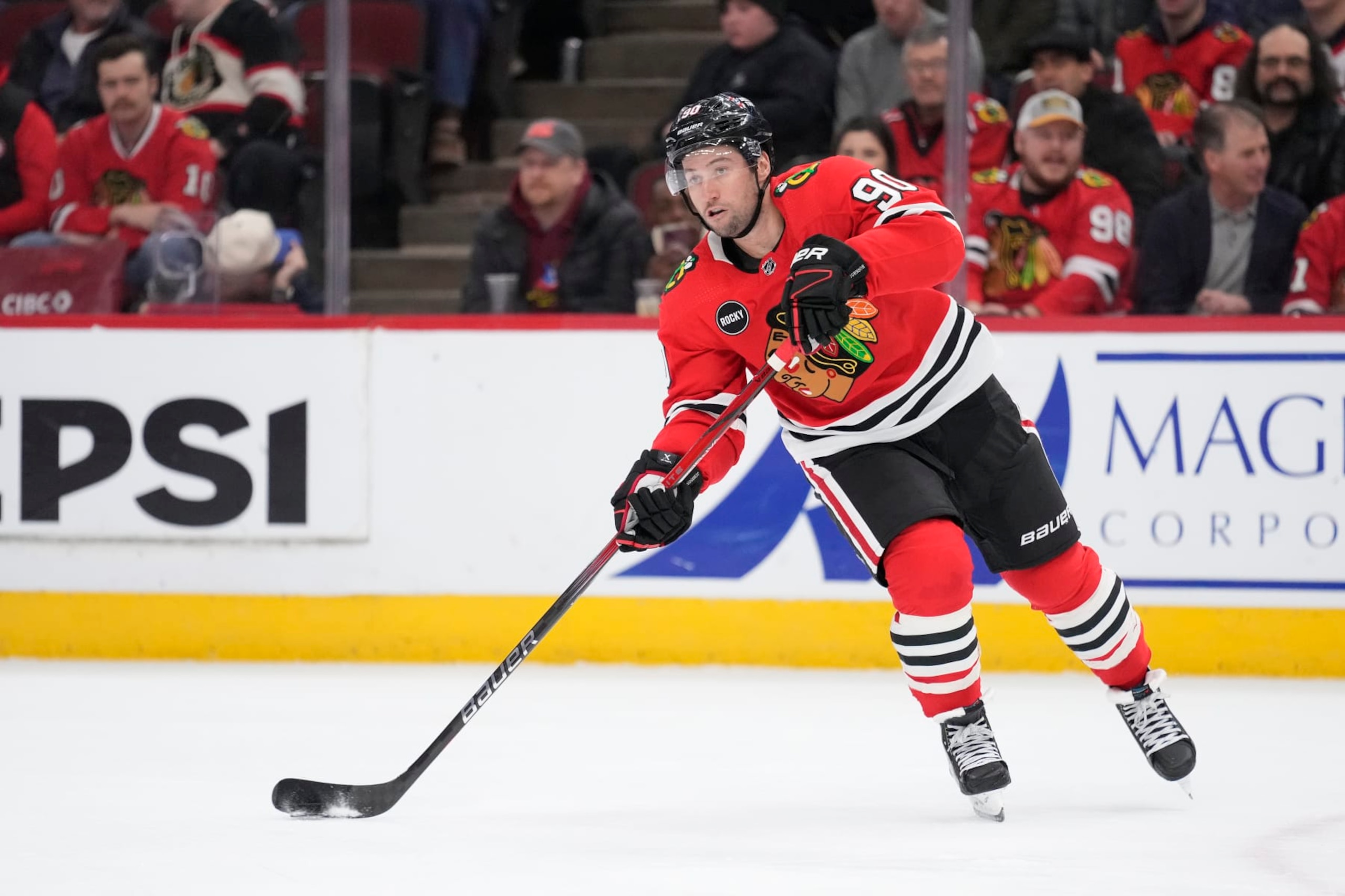 CHICAGO, ILLINOIS - FEBRUARY 13: Tyler Johnson #90 of the Chicago Blackhawks skates with the puck during the first period against the Vancouver Canucks at the United Center on February 13, 2024 in Chicago, Illinois. (Photo by Patrick McDermott/Getty Images)