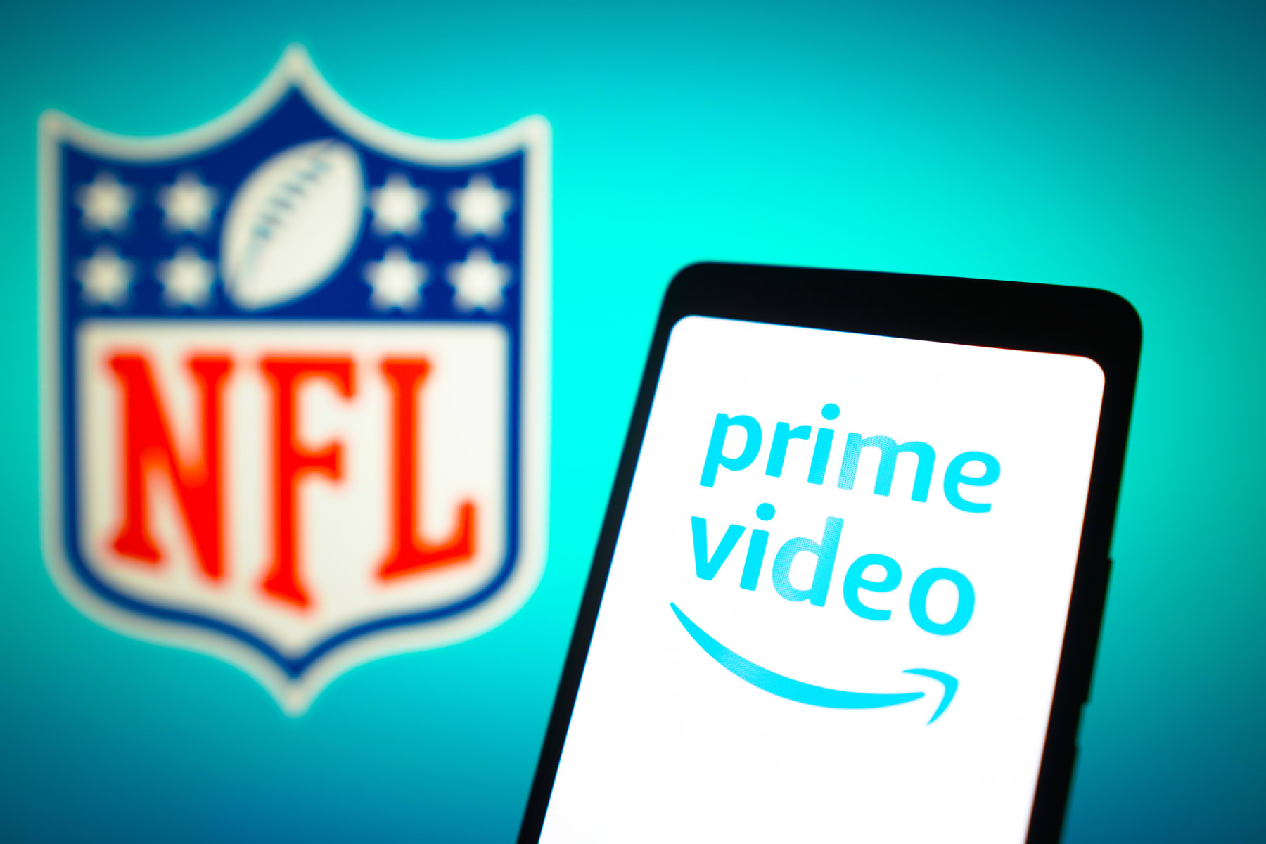 BRAZIL - 2024/01/23: In this photo illustration, the Amazon Prime Video logo is displayed on a smartphone screen and the National Football League (NFL) logo in the background. The NFL partnered with Amazon Prime Video for the streaming rights of Thursday Night Football. This collaboration allowed Amazon Prime subscribers to access Thursday Night Football games through the streaming service. (Photo Illustration by Rafael Henrique/SOPA Images/LightRocket via Getty Images)