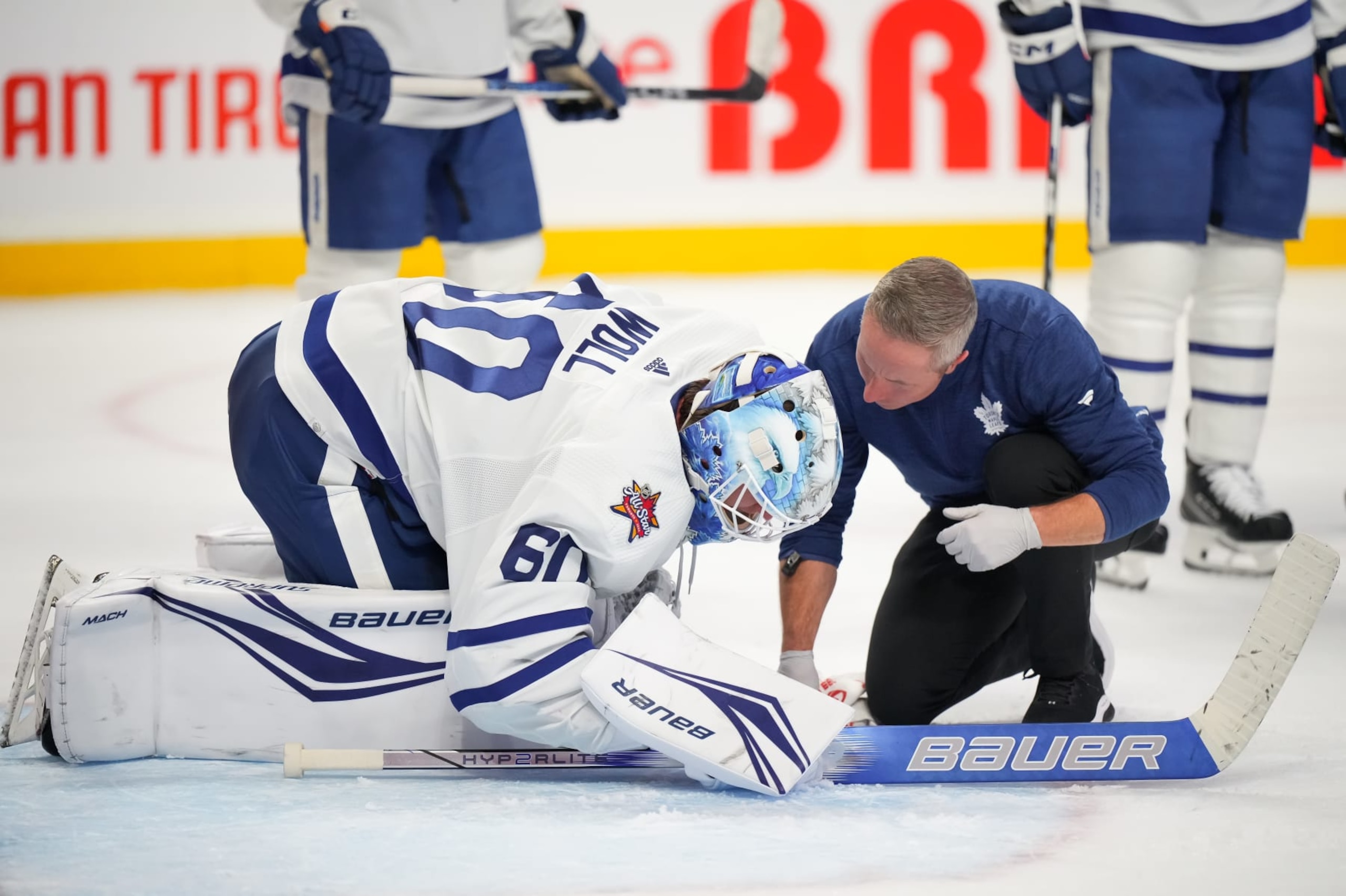 OTTAWA, CANADA - DECEMBER 7: Joseph Woll #60 of the Toronto Maple Leafs speaks to an athletic trainer during a stoppage in play after sustaining an injury against the Ottawa Senators during the third period at Canadian Tire Centre on December 7, 2023 in Ottawa, Ontario, Canada.  (Photo by André Ringuette/NHLI via Getty Images)