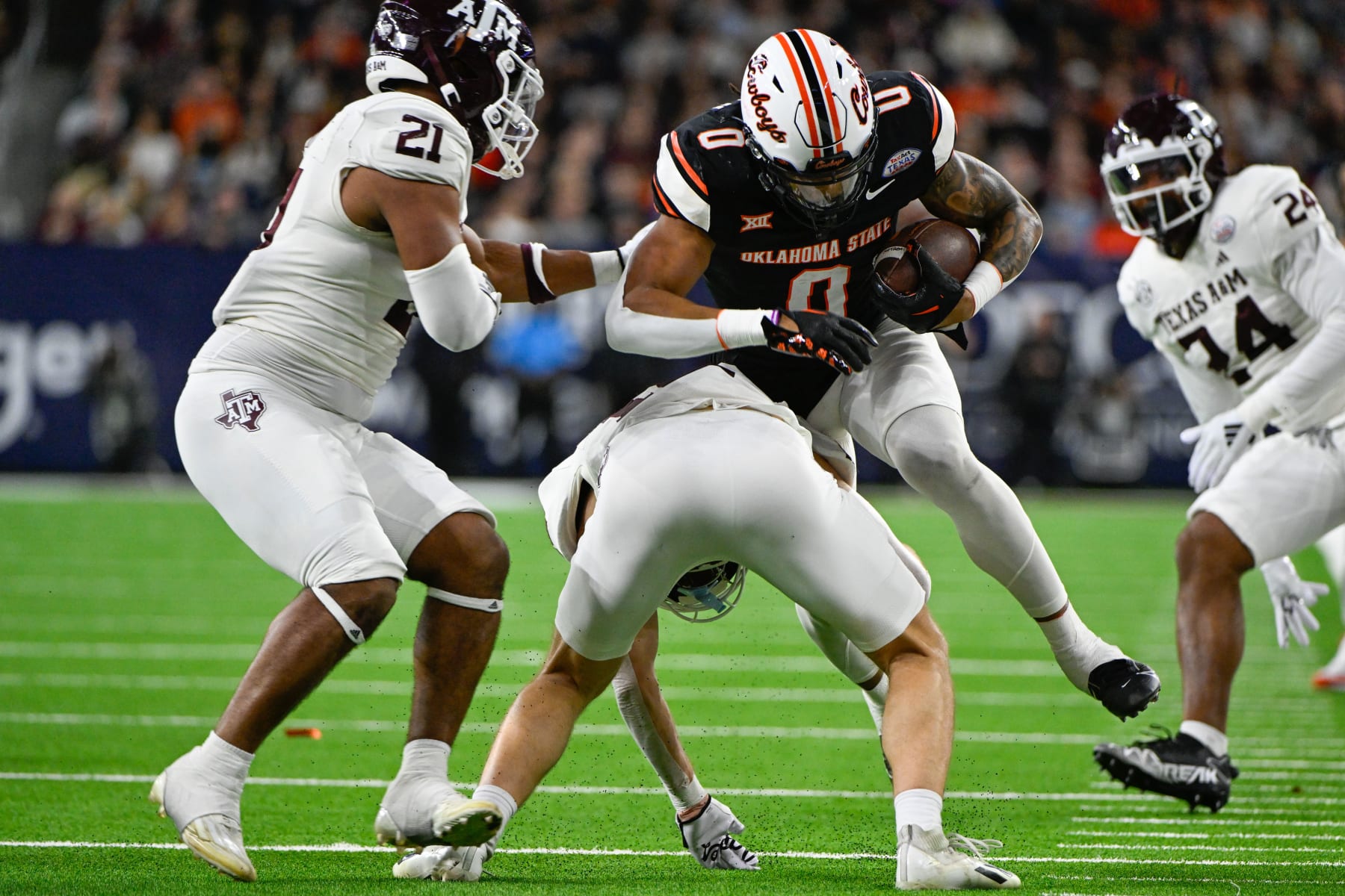 HOUSTON, TX - DECEMBER 27: Oklahoma State Cowboys running back Ollie Gordon II (0) fights for additional yardage after a pass reception during the TaxAct Texas Bowl between the Texas A&M Aggies and Oklahoma State Cowboys at NRG Stadium on December 27, 2023 in Houston, Texas. (Photo by Ken Murray/Icon Sportswire via Getty Images)