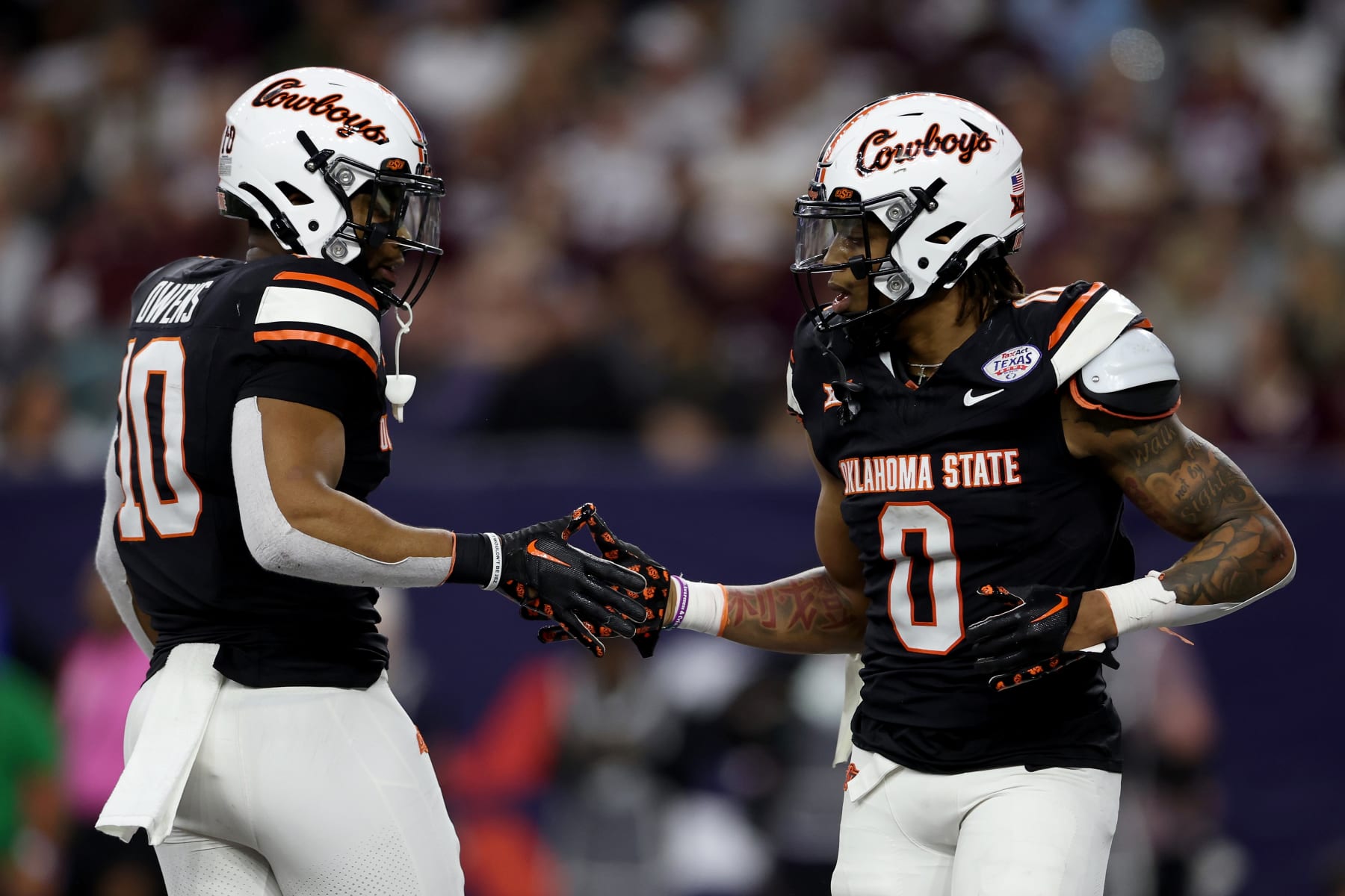 HOUSTON, TEXAS - DECEMBER 27: Ollie Gordon II #0 of the Oklahoma State Cowboys is congratulated by Rashod Owens #10 after a rushing touchdown against the Texas A&M Aggies during the TaxAct Texas Bowl at NRG Stadium on December 27, 2023 in Houston, Texas. (Photo by Tim Warner/Getty Images)