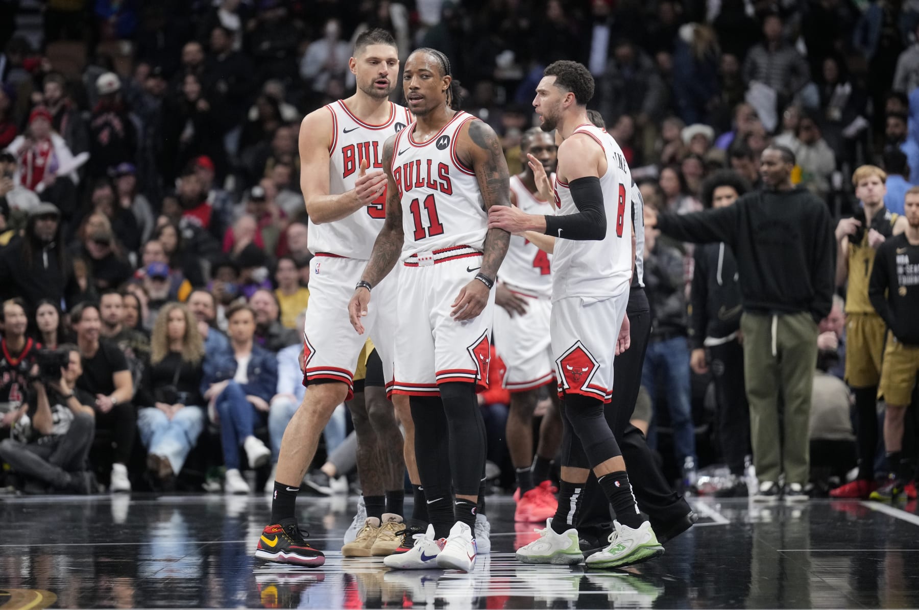 TORONTO, ON - NOVEMBER 24: DeMar DeRozan #11 of the Chicago Bulls reacts at the end of the second half with teammates Nikola Vucevic #9 (L) and Zach LaVine #8 (R) in the NBA In-Season Tournament game against the Toronto Raptors at the Scotiabank Arena on November 24, 2023 in Toronto, Ontario, Canada. NOTE TO USER: User expressly acknowledges and agrees that, by downloading and/or using this Photograph, user is consenting to the terms and conditions of the Getty Images License Agreement. (Photo by Mark Blinch/Getty Images)