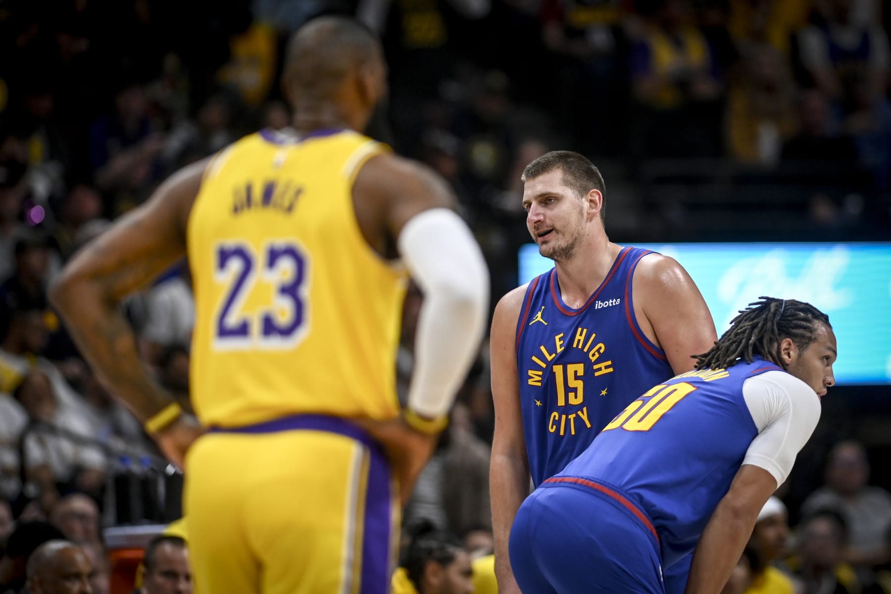 DENVER, CO - OCTOBER 24: Nikola Jokic (15) of the Denver Nuggets speaks to a referee as LeBron James (23) of the Los Angeles Lakers looms during the first quarter at Ball Arena in Denver on Tuesday, October 24, 2023. (Photo by AAron Ontiveroz/The Denver Post)