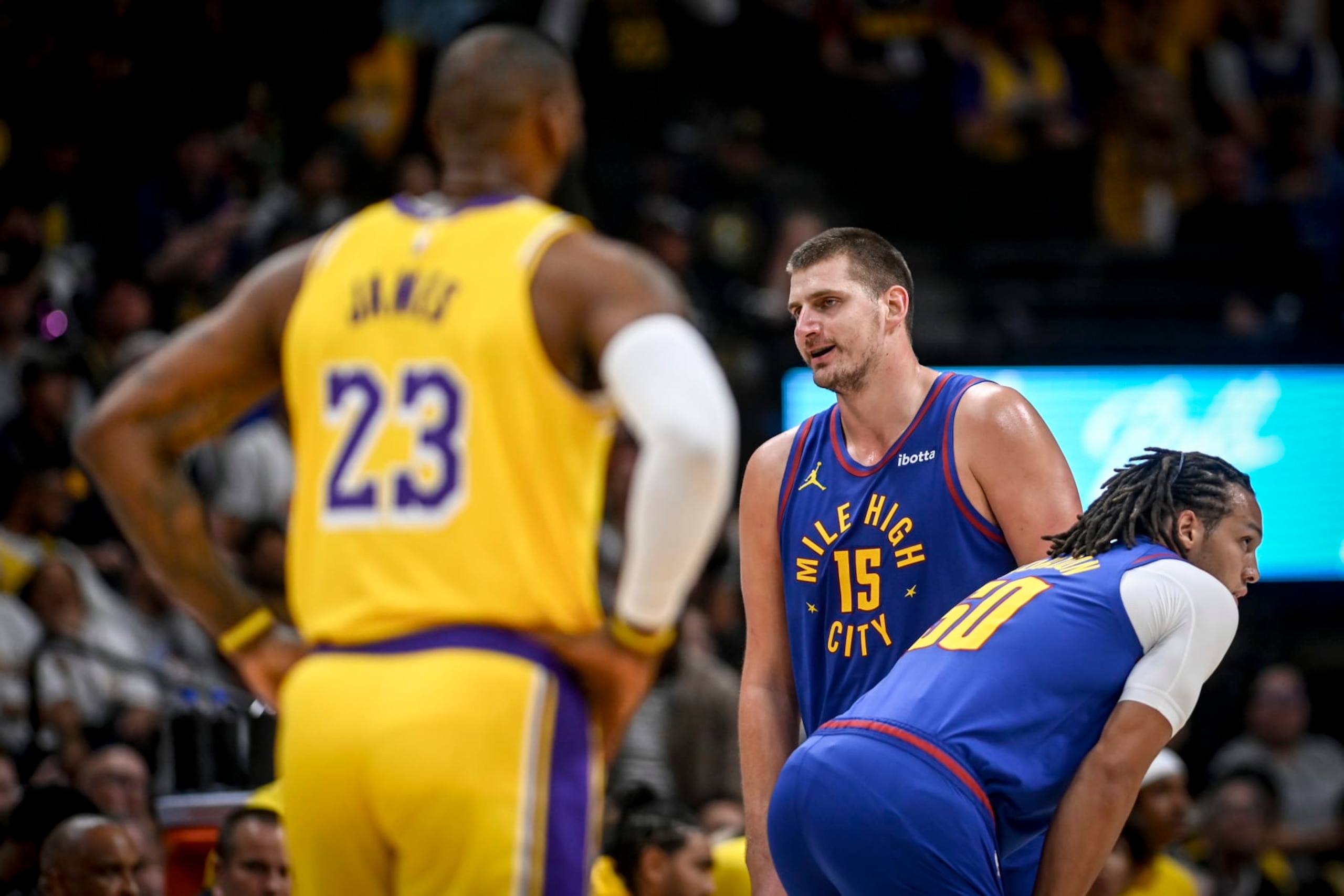 DENVER, CO - OCTOBER 24: Nikola Jokic (15) of the Denver Nuggets speaks to a referee as LeBron James (23) of the Los Angeles Lakers looms during the first quarter at Ball Arena in Denver on Tuesday, October 24, 2023. (Photo by AAron Ontiveroz/The Denver Post)