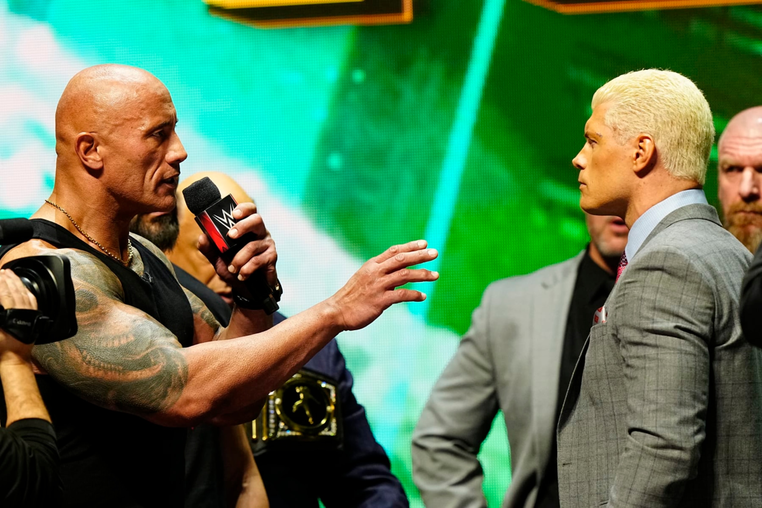 LAS VEGAS, NV - FEBRUARY 08:  Dwayne "The Rock" Johnson and Cody Rhodes face-off on stage during the WWE Wrestlemania XL Kickoff on February 08, 2024, at T-Mobile Arena in Las Vegas, NV. (Photo by Louis Grasse/PXimages/Icon Sportswire via Getty Images)