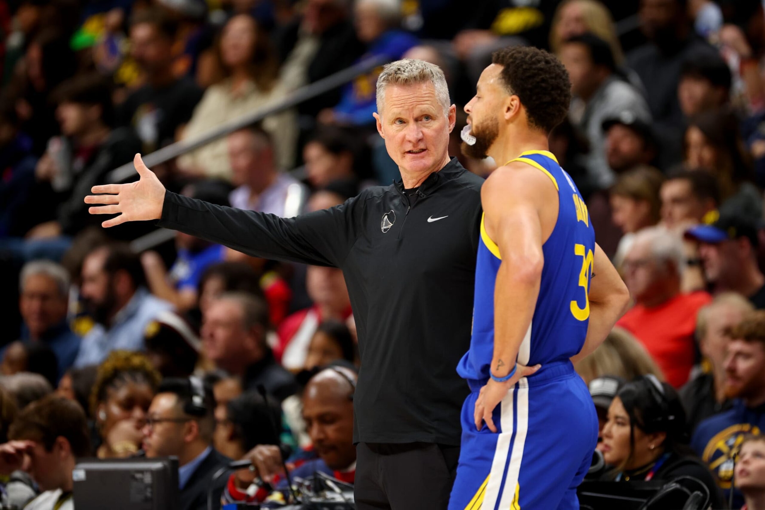 DENVER, COLORADO - DECEMBER 25: Head Coach Steve Kerr of the Golden State Warriors speaks with Stephen Curry #30 against the Denver Nuggets at Ball Arena on December 25, 2023 in Denver, Colorado. NOTE TO USER: User expressly acknowledges and agrees that, by downloading and/or using this Photograph, user is consenting to the terms and conditions of the Getty Images License Agreement. (Photo by Jamie Schwaberow/Getty Images)