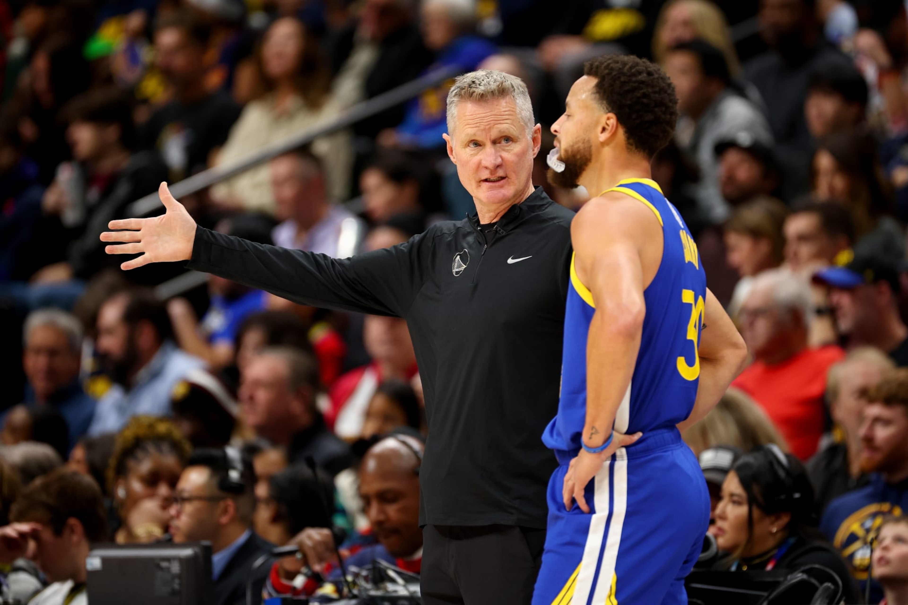 DENVER, COLORADO - DECEMBER 25: Head Coach Steve Kerr of the Golden State Warriors speaks with Stephen Curry #30 against the Denver Nuggets at Ball Arena on December 25, 2023 in Denver, Colorado. NOTE TO USER: User expressly acknowledges and agrees that, by downloading and/or using this Photograph, user is consenting to the terms and conditions of the Getty Images License Agreement. (Photo by Jamie Schwaberow/Getty Images)
