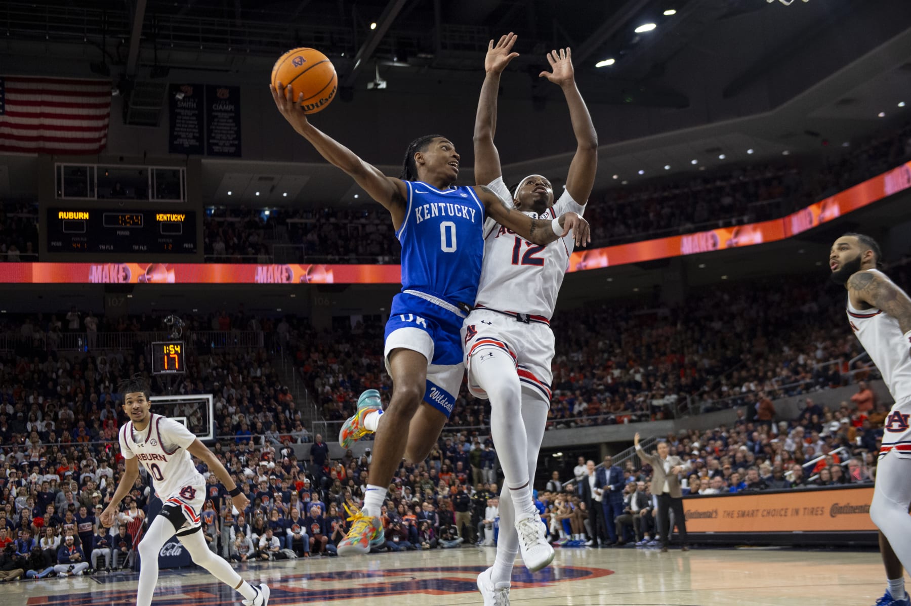 AUBURN, ALABAMA - FEBRUARY 17: Rob Dillingham #0 of the Kentucky Wildcats looks to pass the ball by Denver Jones #12 of the Auburn Tigers during the first half of play at Neville Arena on February 17, 2024 in Auburn, Alabama. (Photo by Michael Chang/Getty Images)