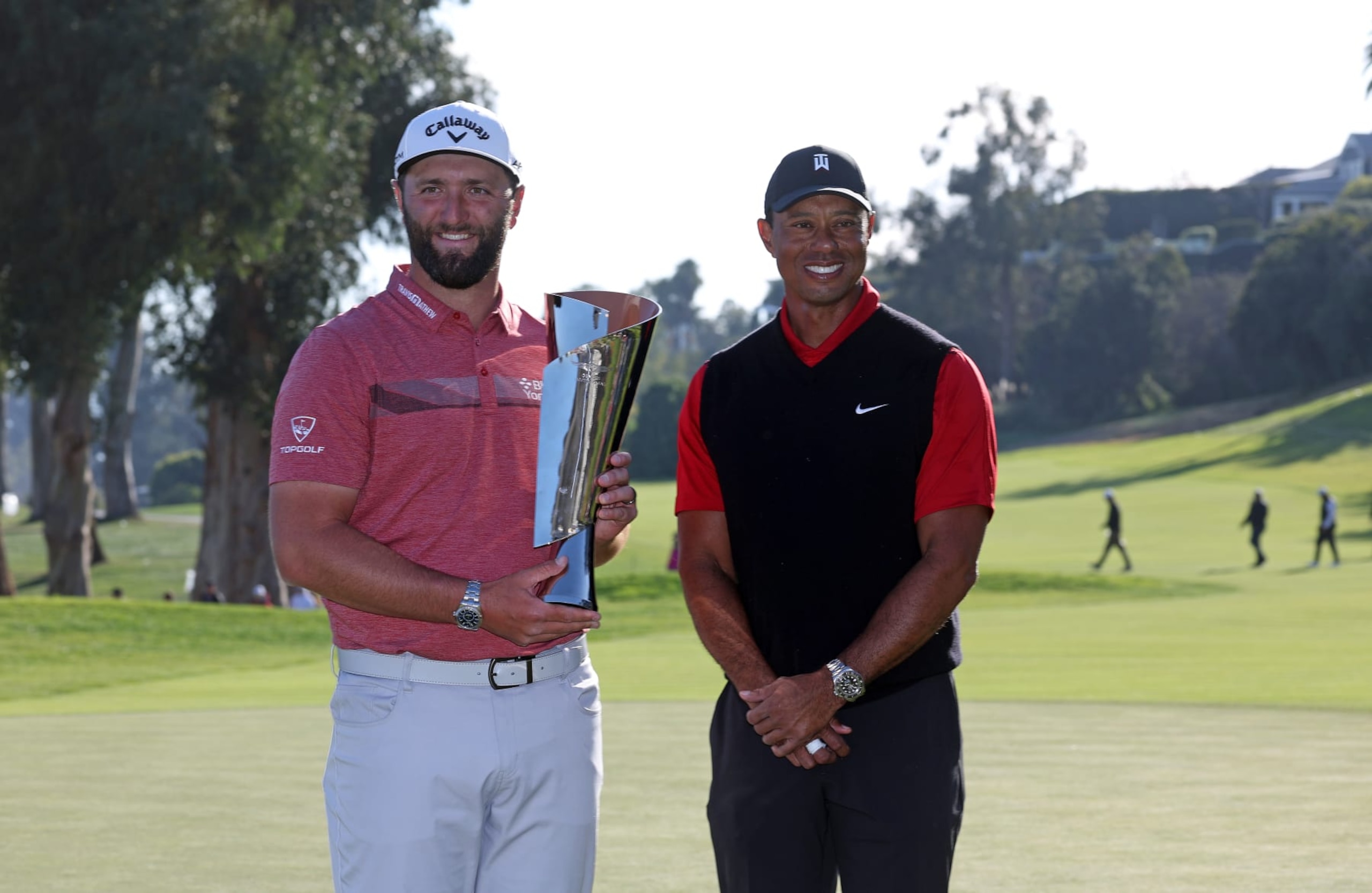 PACIFIC PALISADES, CALIFORNIA - FEBRUARY 19: The Genesis Invitational host, Tiger Woods of the United States, presents the trophy to Jon Rahm of Spain after putting in to win The Genesis Invitational at Riviera Country Club on the 18th green on February 19, 2023 in Pacific Palisades, California. (Photo by Harry How/Getty Images) PACIFIC PALISADES, CALIFORNIA - FEBRUARY 19: The Genesis Invitational host, Tiger Woods of the United States, presents the trophy to Jon Rahm of Spain after putting in to win The Genesis Invitational at Riviera Country Club on the 18th green on February 19, 2023 in Pacific Palisades, California. (Photo by Harry How/Getty Images)