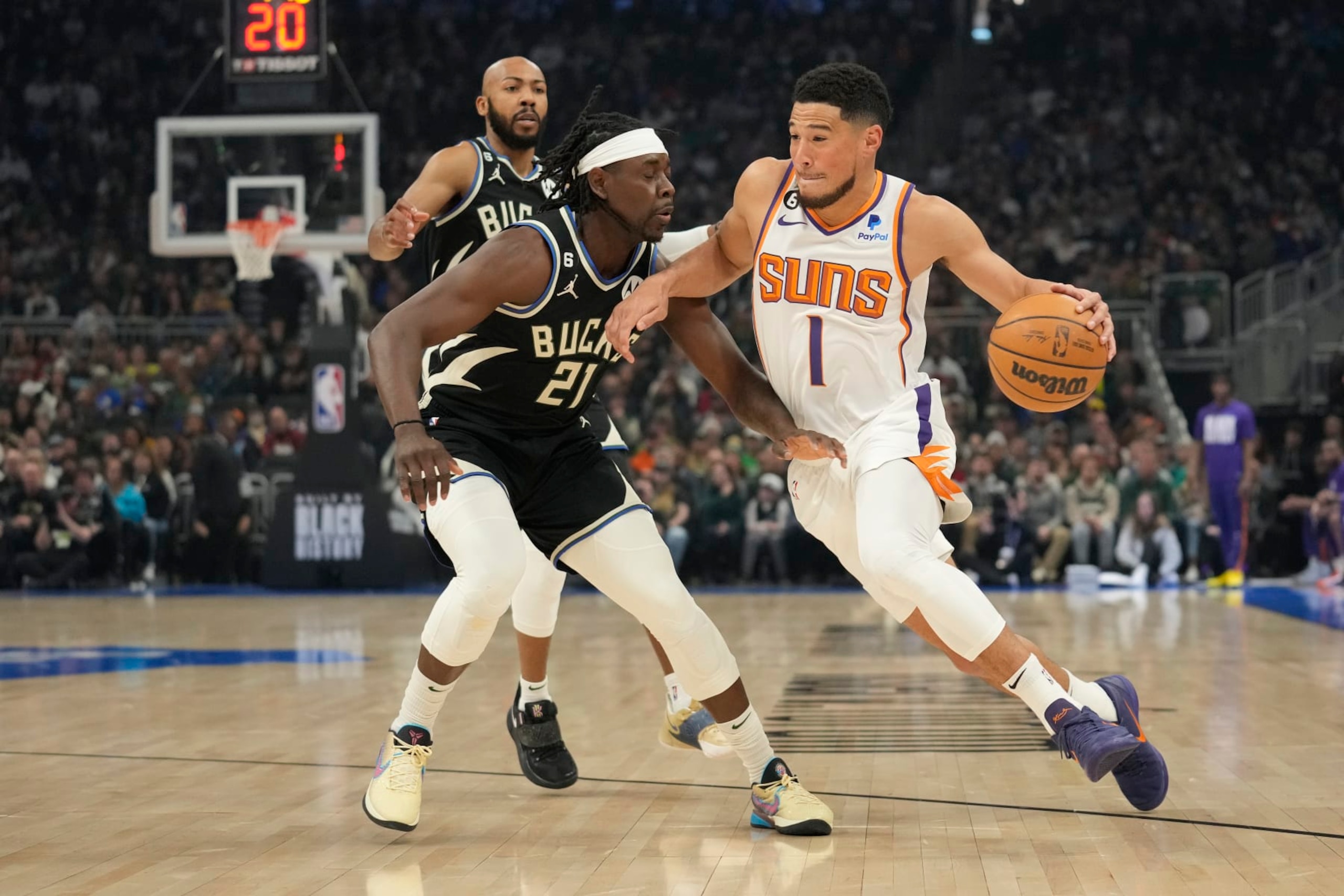 MILWAUKEE, WISCONSIN - FEBRUARY 26: Devin Booker #1 of the Phoenix Suns dribbles the ball against Jrue Holiday #21 of the Milwaukee Bucks in the first half of the game at Fiserv Forum on February 26, 2023 in Milwaukee, Wisconsin. NOTE TO USER: User expressly acknowledges and agrees that, by downloading and or using this photograph, user is consenting to the terms and conditions of the Getty Images License Agreement. (Photo by Patrick McDermott/Getty Images)