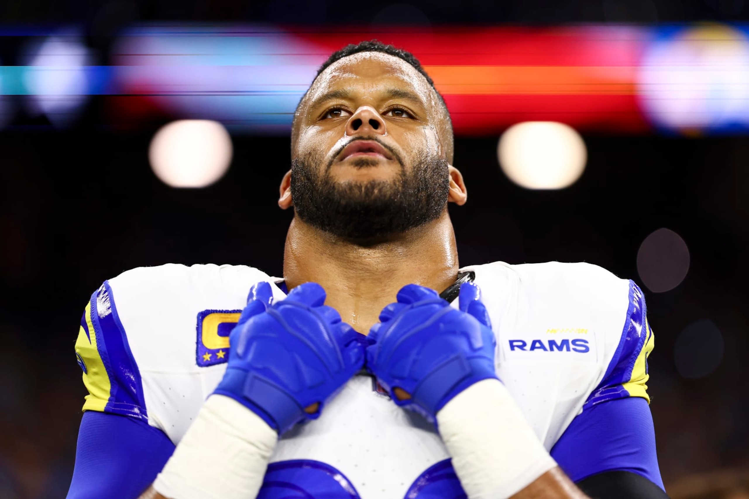DETROIT, MI - JANUARY 14: Aaron Donald #99 of the Los Angeles Rams stands on the sidelines during the national anthem prior to an NFL wild-card playoff football game against the Detroit Lions at Ford Field on January 14, 2024 in Detroit, Michigan. (Photo by Kevin Sabitus/Getty Images) DETROIT, MI - JANUARY 14: Aaron Donald #99 of the Los Angeles Rams stands on the sidelines during the national anthem prior to an NFL wild-card playoff football game against the Detroit Lions at Ford Field on January 14, 2024 in Detroit, Michigan. (Photo by Kevin Sabitus/Getty Images)