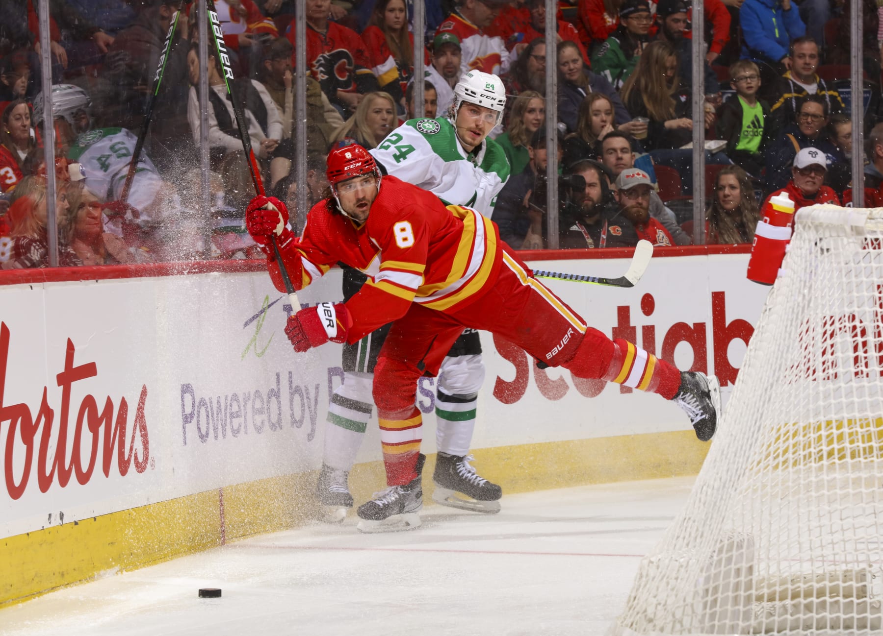 CALGARY, ALBERTA - MARCH 18: Chris Tanev #8 of the Calgary Flames checks Roope Hintz #24 of the Dallas Stars at Scotiabank Saddledome on March 18, 2023 in Calgary, Alberta. (Photo by Gerry Thomas/NHLI via Getty Images)