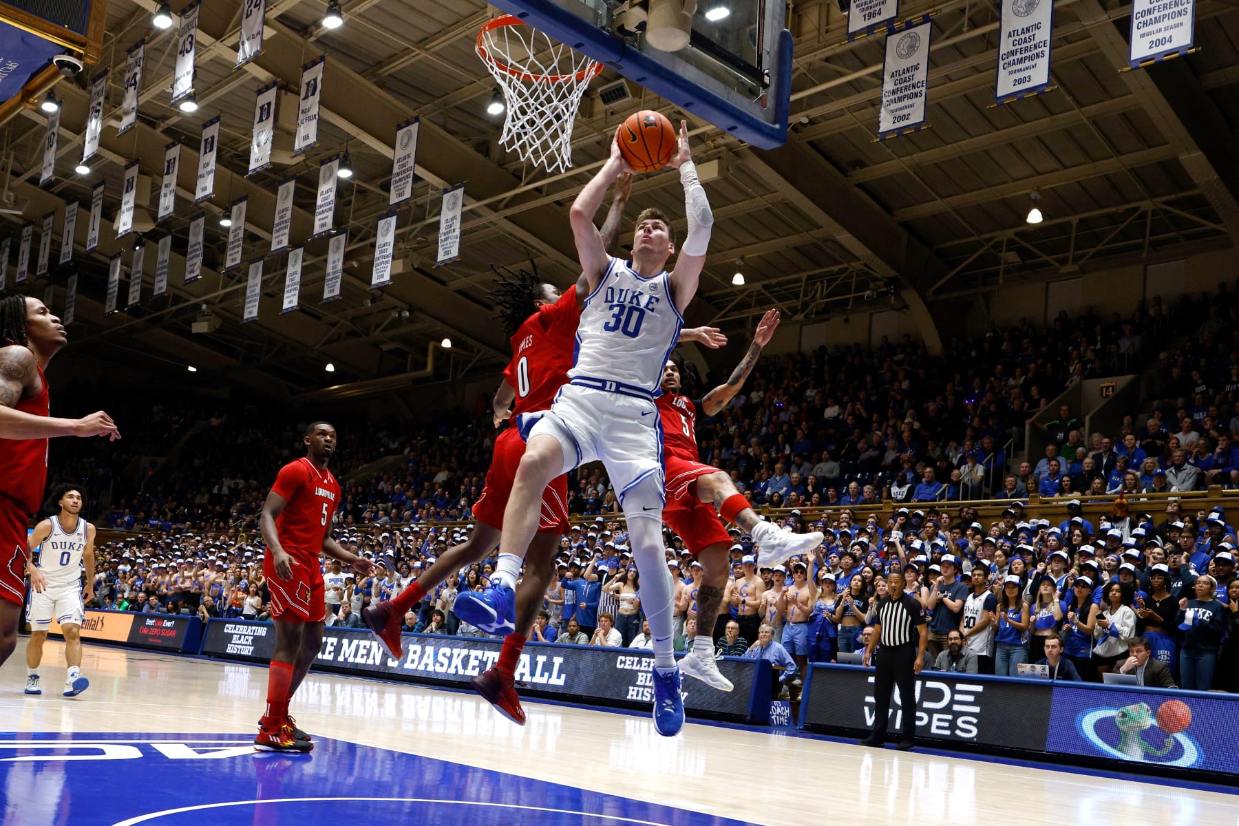 DURHAM, NORTH CAROLINA - FEBRUARY 28: Kyle Filipowski #30 of the Duke Blue Devils goes to the basket against Mike James #0 and Skyy Clark #55 of the Louisville Cardinals during the first half of the game at Cameron Indoor Stadium on February 28, 2024 in Durham, North Carolina. (Photo by Lance King/Getty Images)