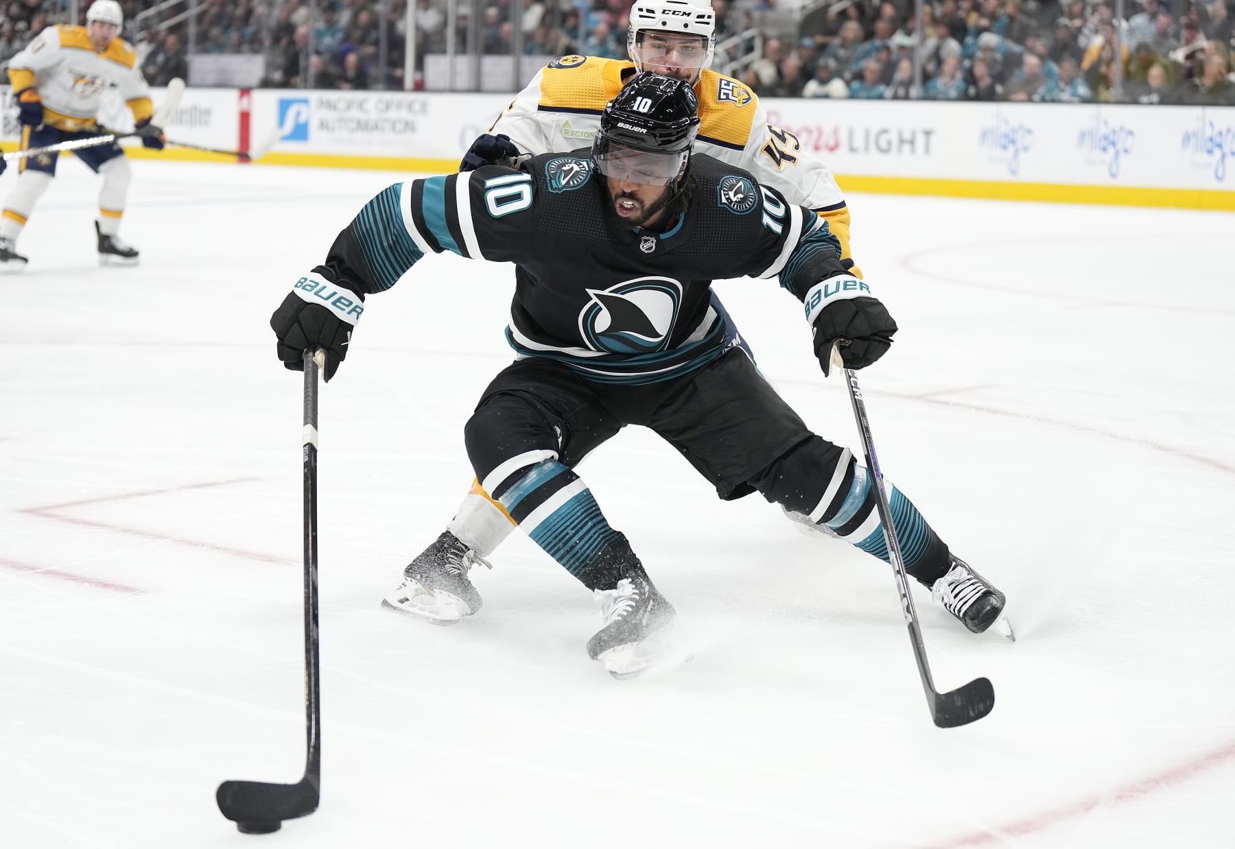 SAN JOSE, CALIFORNIA - FEBRUARY 24: Anthony Duclair #10 of the San Jose Sharks skates with the puck defended by Alexandre Carrier #45 of the Nashville Predators during the second period period of an NHL hockey game at SAP Center on February 24, 2024 in San Jose, California. (Photo by Thearon W. Henderson/Getty Images)
