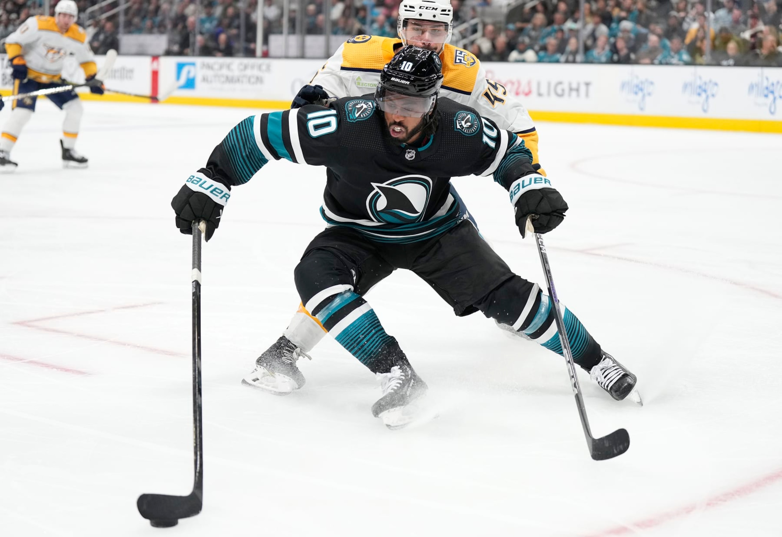 SAN JOSE, CALIFORNIA - FEBRUARY 24: Anthony Duclair #10 of the San Jose Sharks skates with the puck defended by Alexandre Carrier #45 of the Nashville Predators during the second period period of an NHL hockey game at SAP Center on February 24, 2024 in San Jose, California. (Photo by Thearon W. Henderson/Getty Images)