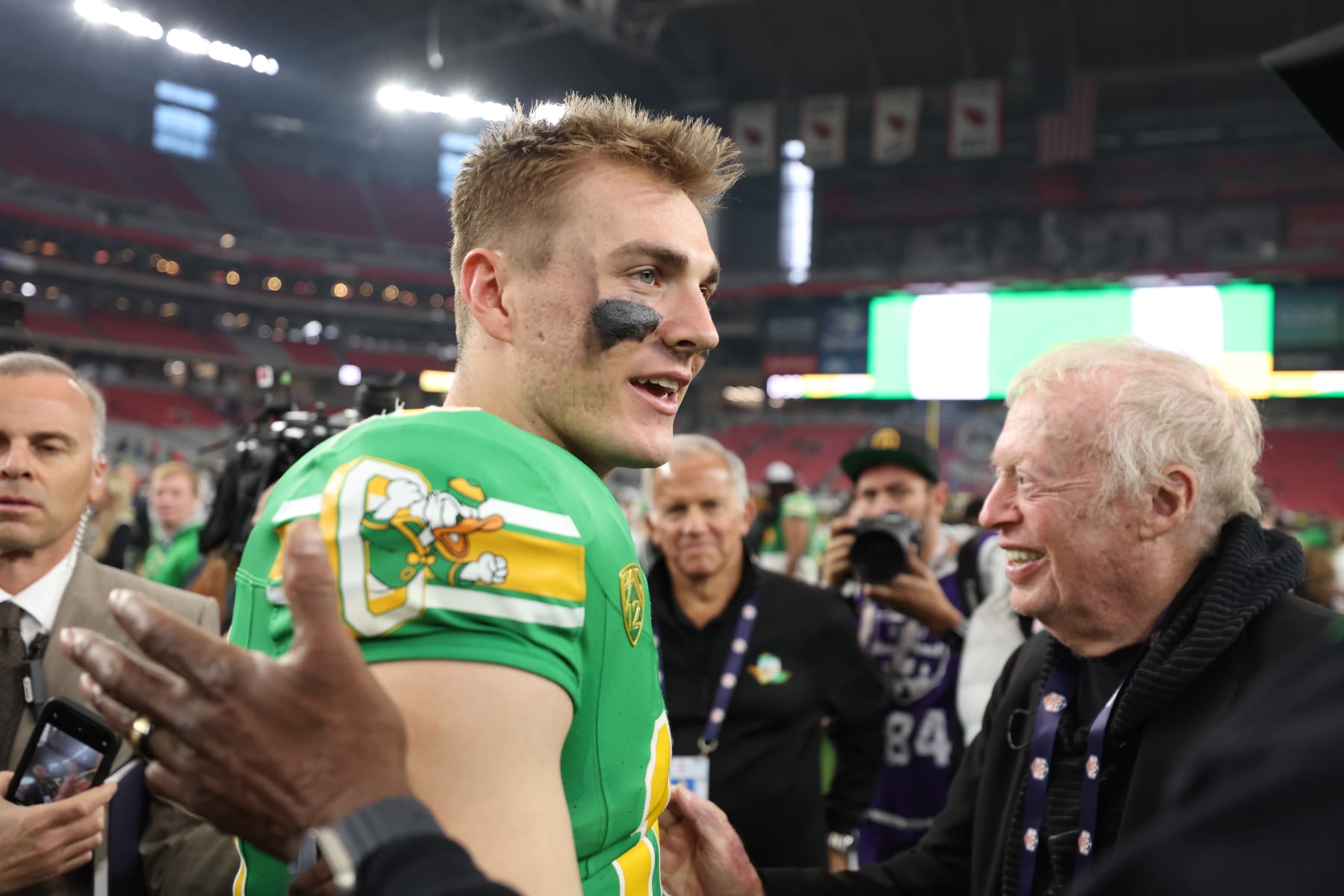 GLENDALE, ARIZONA - JANUARY 01: Founder and current chairman emeritus of Nike, Inc Phil Knight (R) congratulates quarterback Bo Nix #10 of the Oregon Ducks following the Fiesta Bowl at State Farm Stadium on January 01, 2024 in Glendale, Arizona. The Ducks defeated the Flames 45-6. (Photo by Christian Petersen/Getty Images)