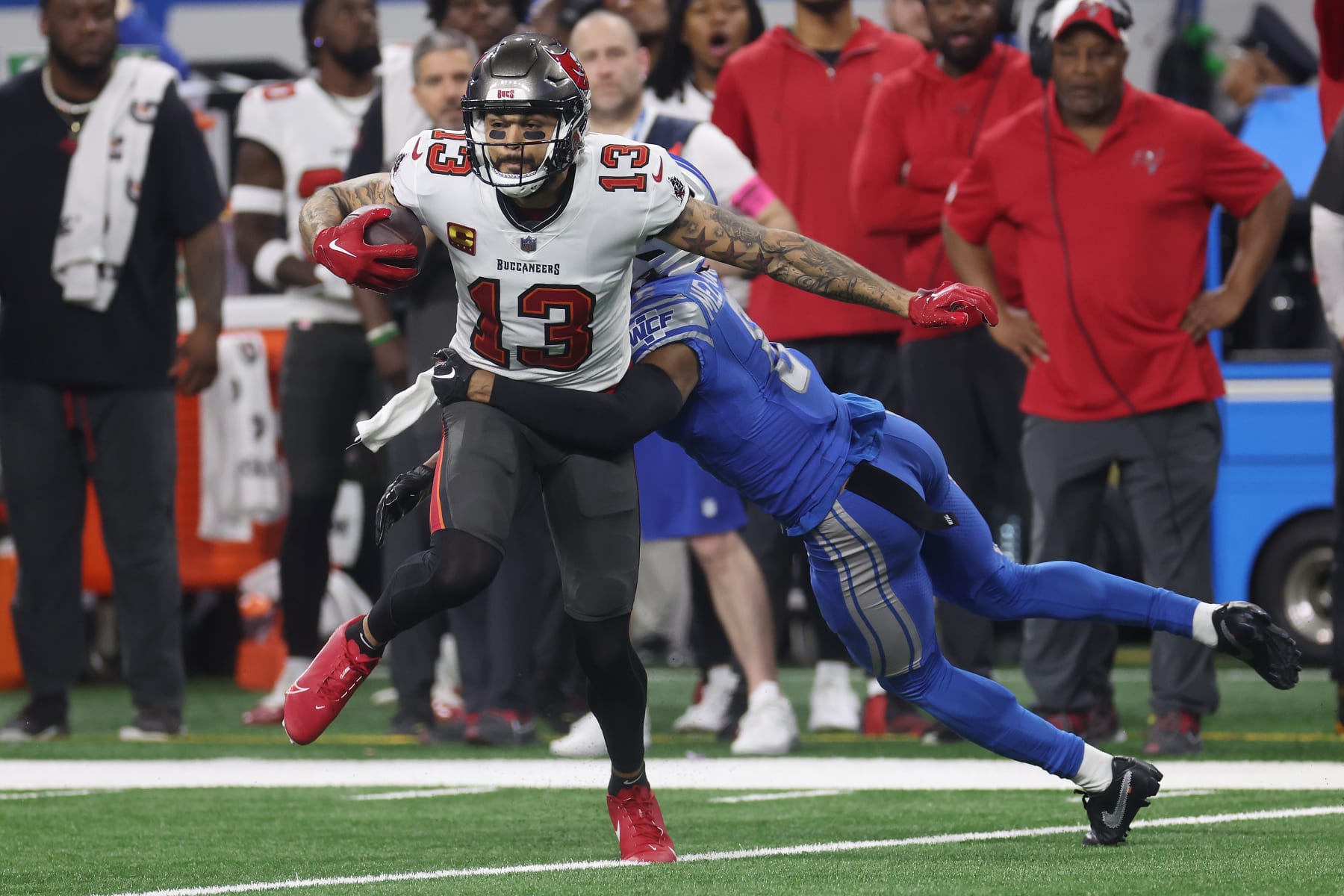 DETROIT, MICHIGAN - JANUARY 21: Mike Evans #13 of the Tampa Bay Buccaneers catches a pass in front of Ifeatu Melifonwu #6 of the Detroit Lions during the second quarter of the NFC Divisional Playoff game at Ford Field on January 21, 2024 in Detroit, Michigan. (Photo by Gregory Shamus/Getty Images)