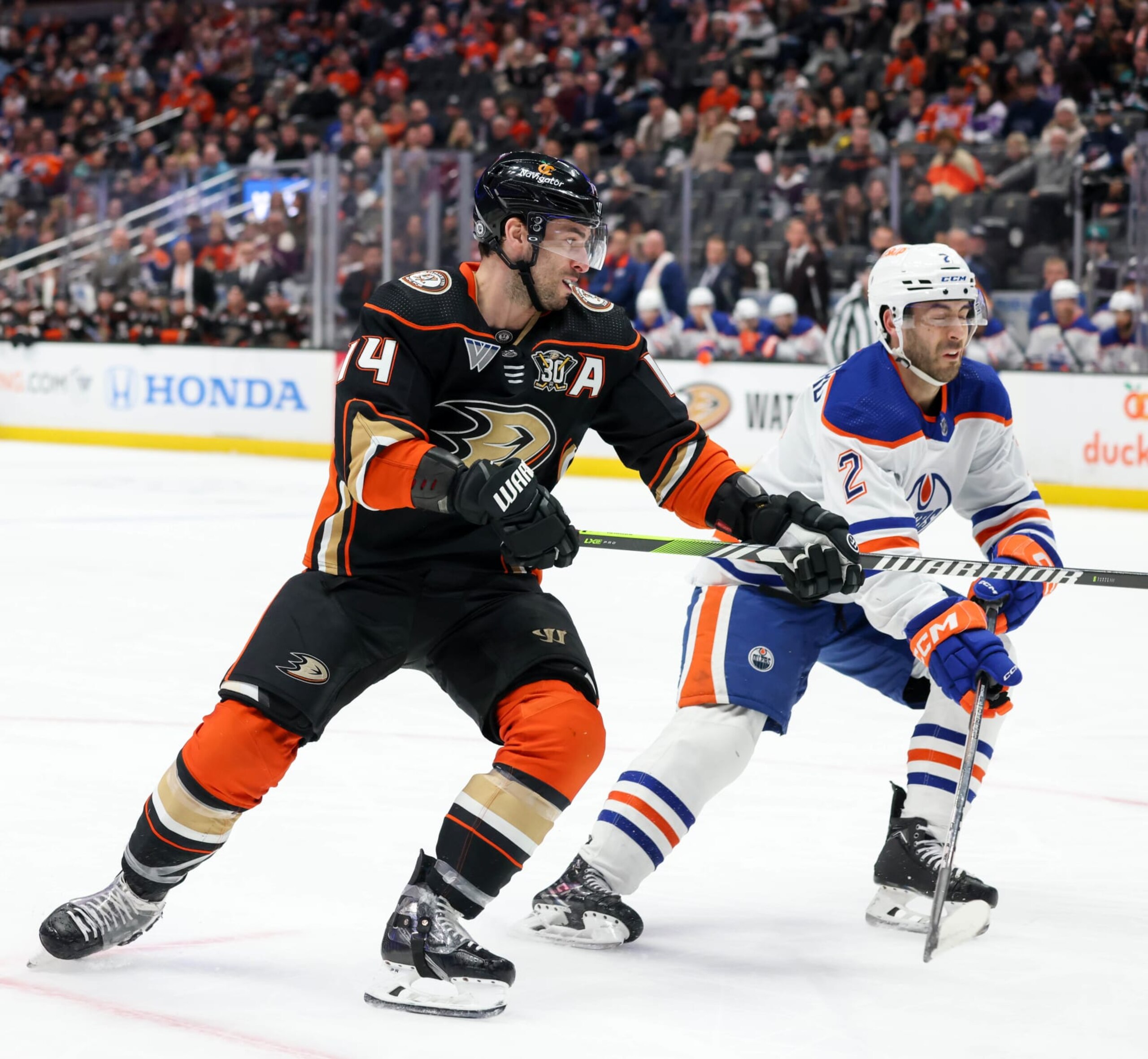 ANAHEIM, CA - FEBRUARY 9:  Adam Henrique #14 of the Anaheim Ducks and Evan Bouchard #2 of the Edmonton Oilers battle for position during the first period at Honda Center on February 9, 2024 in Anaheim, California. (Photo by Debora Robinson/NHLI via Getty Images)