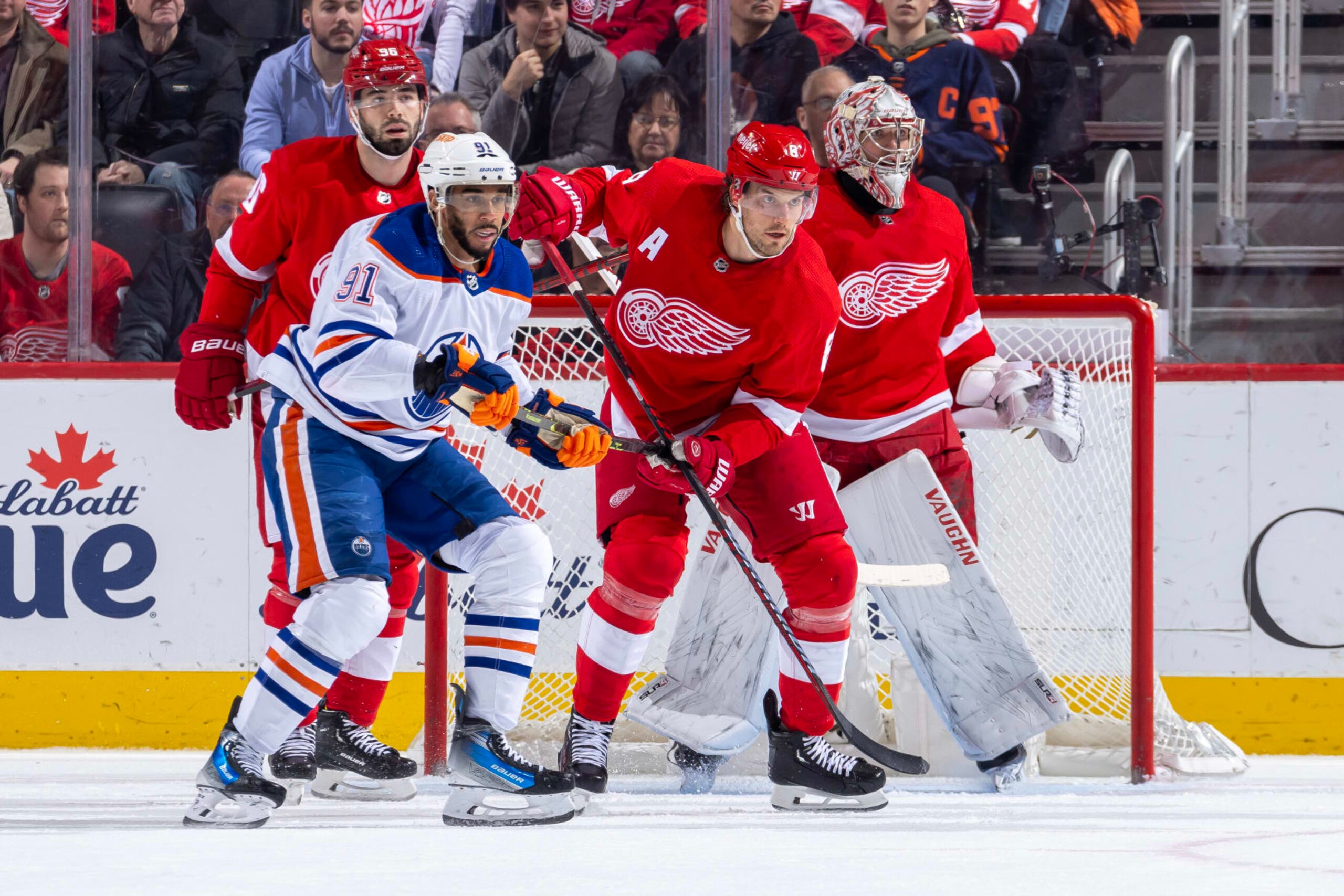 DETROIT, MI - JANUARY 11: Goalie Alex Lyon (34) of the Detroit Red Wings and teammate Ben Chiarot (8) follow the puck as Evander Kane (91) of the Edmonton Oilers battles for position during the first period at Little Caesars Arena on January 11, 2024 in Detroit, Michigan. (Photo by Dave Reginek/NHLI via Getty Images)