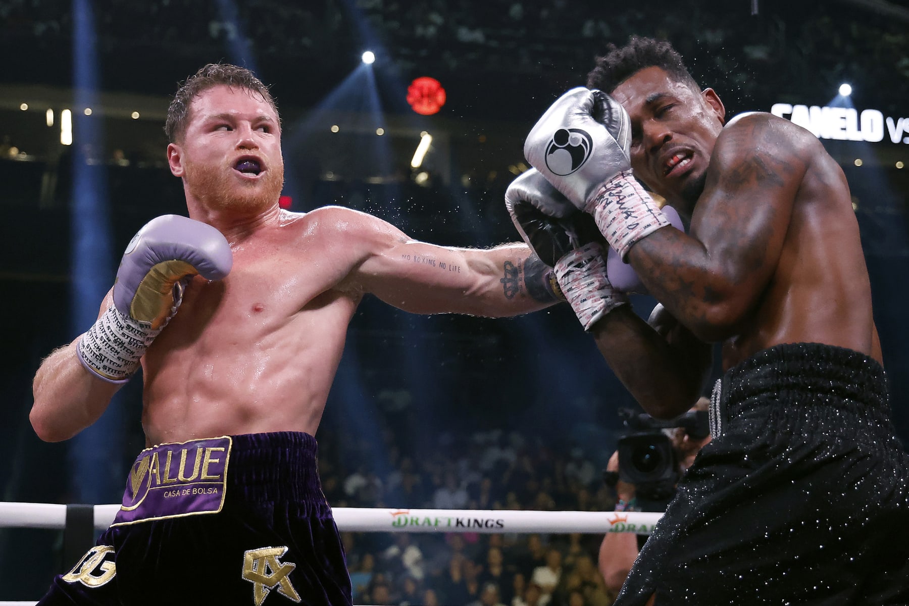 LAS VEGAS, NEVADA - SEPTEMBER 30:   Saul "Canelo" Alvarez of Mexico (purple/gold trunks) trades punches with Jermell Charlo (black trunks) during their super middleweight title fight at T-Mobile Arena on September 30, 2023 in Las Vegas, Nevada.  (Photo by Sarah Stier/Getty Images)