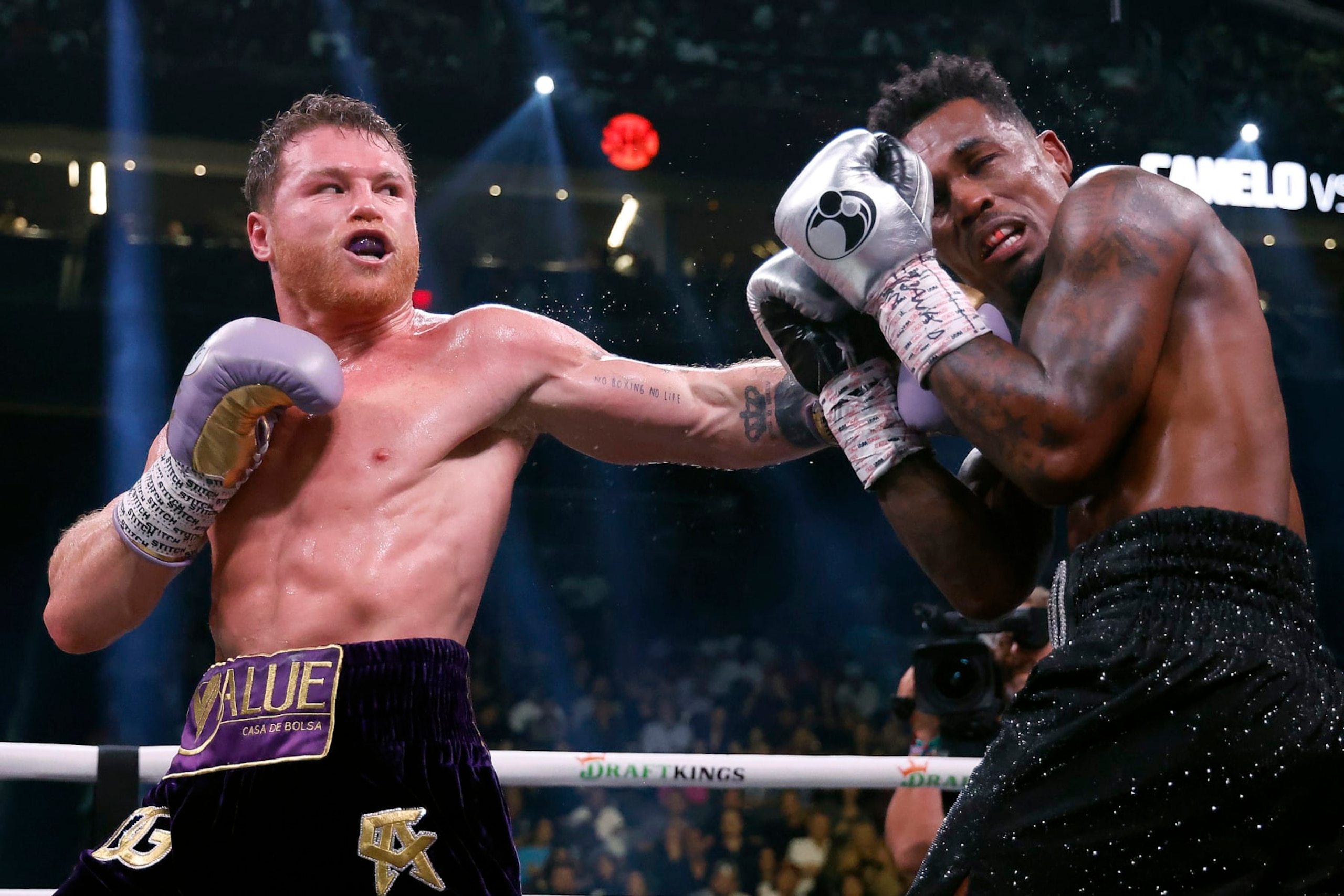 LAS VEGAS, NEVADA - SEPTEMBER 30:   Saul "Canelo" Alvarez of Mexico (purple/gold trunks) trades punches with Jermell Charlo (black trunks) during their super middleweight title fight at T-Mobile Arena on September 30, 2023 in Las Vegas, Nevada.  (Photo by Sarah Stier/Getty Images)