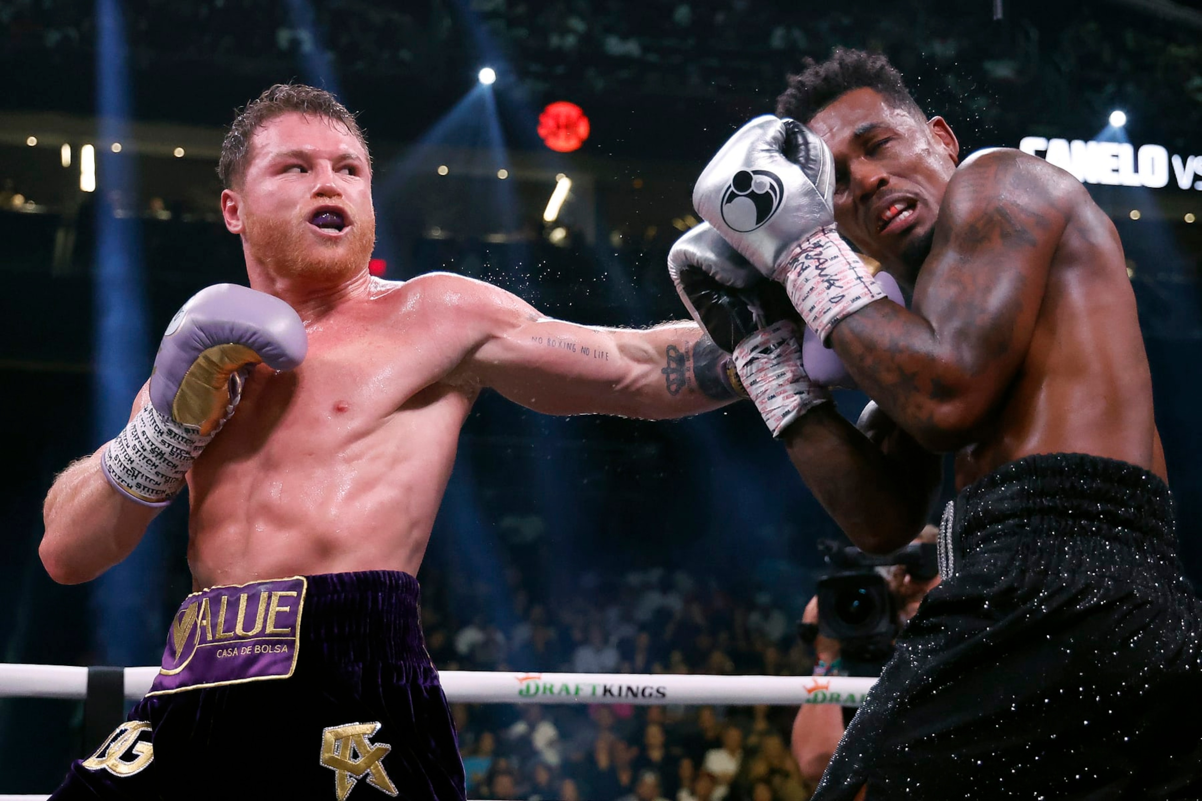 LAS VEGAS, NEVADA - SEPTEMBER 30:   Saul "Canelo" Alvarez of Mexico (purple/gold trunks) trades punches with Jermell Charlo (black trunks) during their super middleweight title fight at T-Mobile Arena on September 30, 2023 in Las Vegas, Nevada.  (Photo by Sarah Stier/Getty Images)