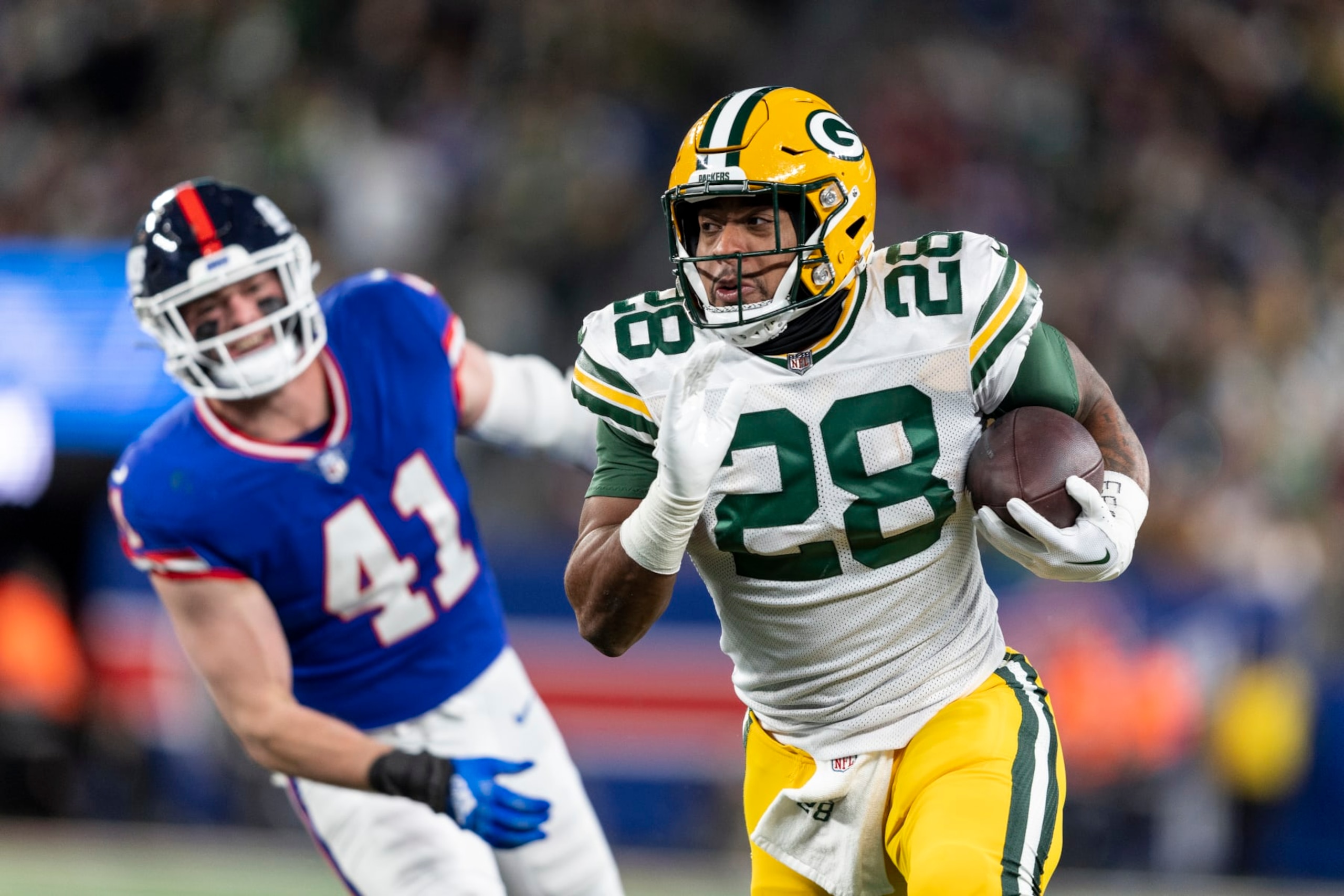 EAST RUTHERFORD, NEW JERSEY - DECEMBER 11: AJ Dillon #28 of the Green Bay Packers runs with the ball during an NFL football game between the New York Giants and the Green Bay Packers at MetLife Stadium on December 11, 2023 in East Rutherford, New Jersey. (Photo by Michael Owens/Getty Images)