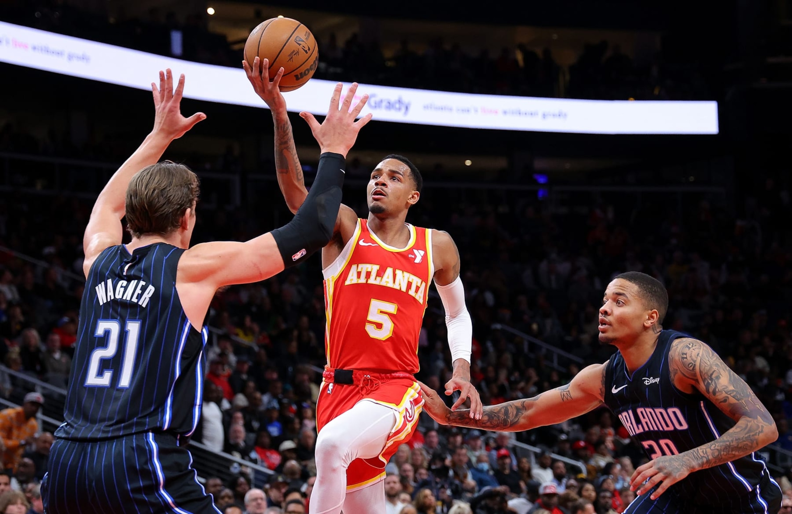 ATLANTA, GEORGIA - FEBRUARY 25:  Dejounte Murray #5 of the Atlanta Hawks drives against Moritz Wagner #21 and Markelle Fultz #20 of the Orlando Magic during the third quarter at State Farm Arena on February 25, 2024 in Atlanta, Georgia.  NOTE TO USER: User expressly acknowledges and agrees that, by downloading and/or using this photograph, user is consenting to the terms and conditions of the Getty Images License Agreement.  (Photo by Kevin C. Cox/Getty Images)