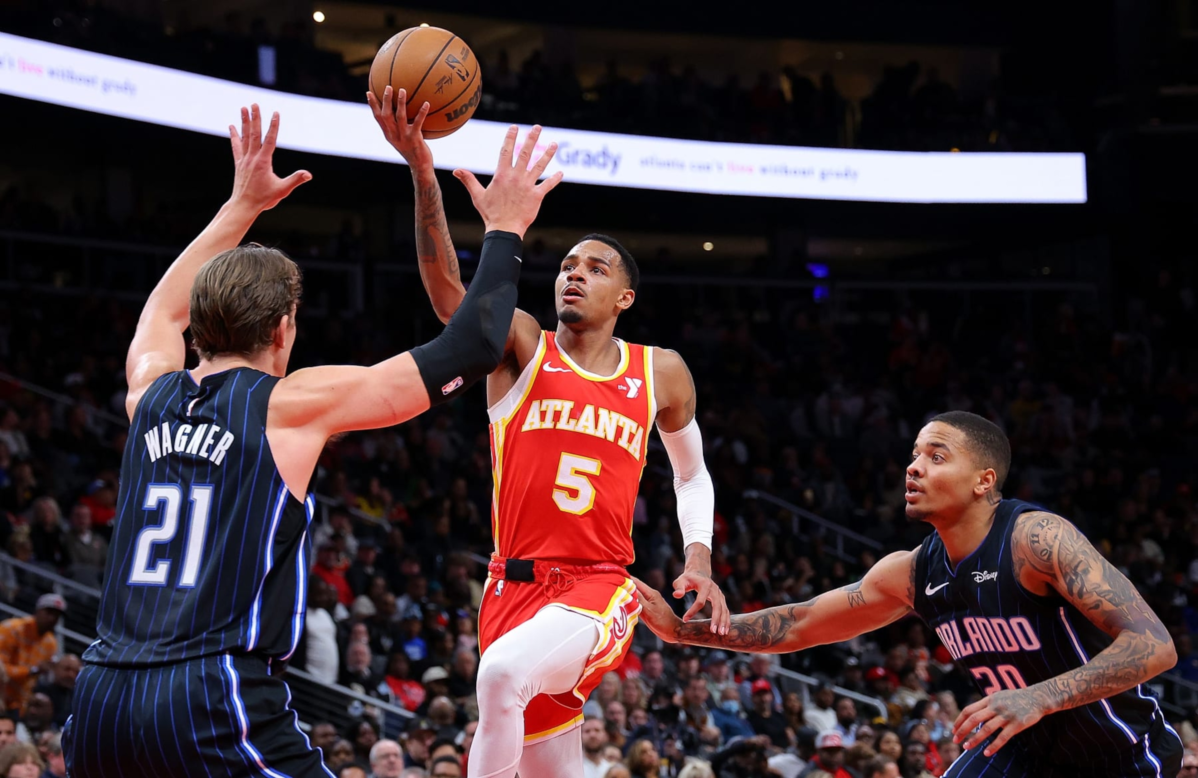 ATLANTA, GEORGIA - FEBRUARY 25:  Dejounte Murray #5 of the Atlanta Hawks drives against Moritz Wagner #21 and Markelle Fultz #20 of the Orlando Magic during the third quarter at State Farm Arena on February 25, 2024 in Atlanta, Georgia.  NOTE TO USER: User expressly acknowledges and agrees that, by downloading and/or using this photograph, user is consenting to the terms and conditions of the Getty Images License Agreement.  (Photo by Kevin C. Cox/Getty Images)