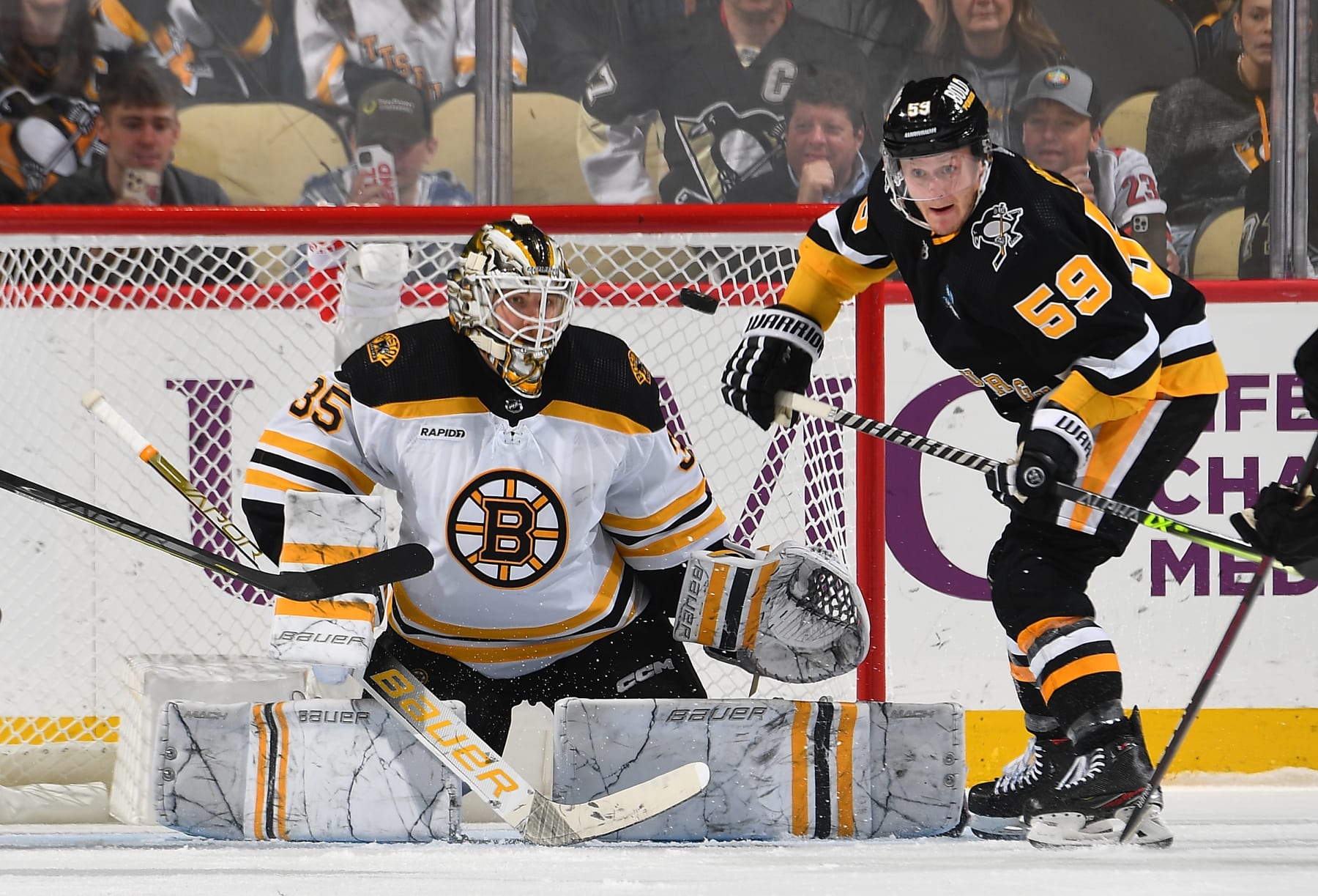 Pittsburgh Penguins winger Jake Guentzel (right) and Boston Bruins goaltender Linus Ullmark.