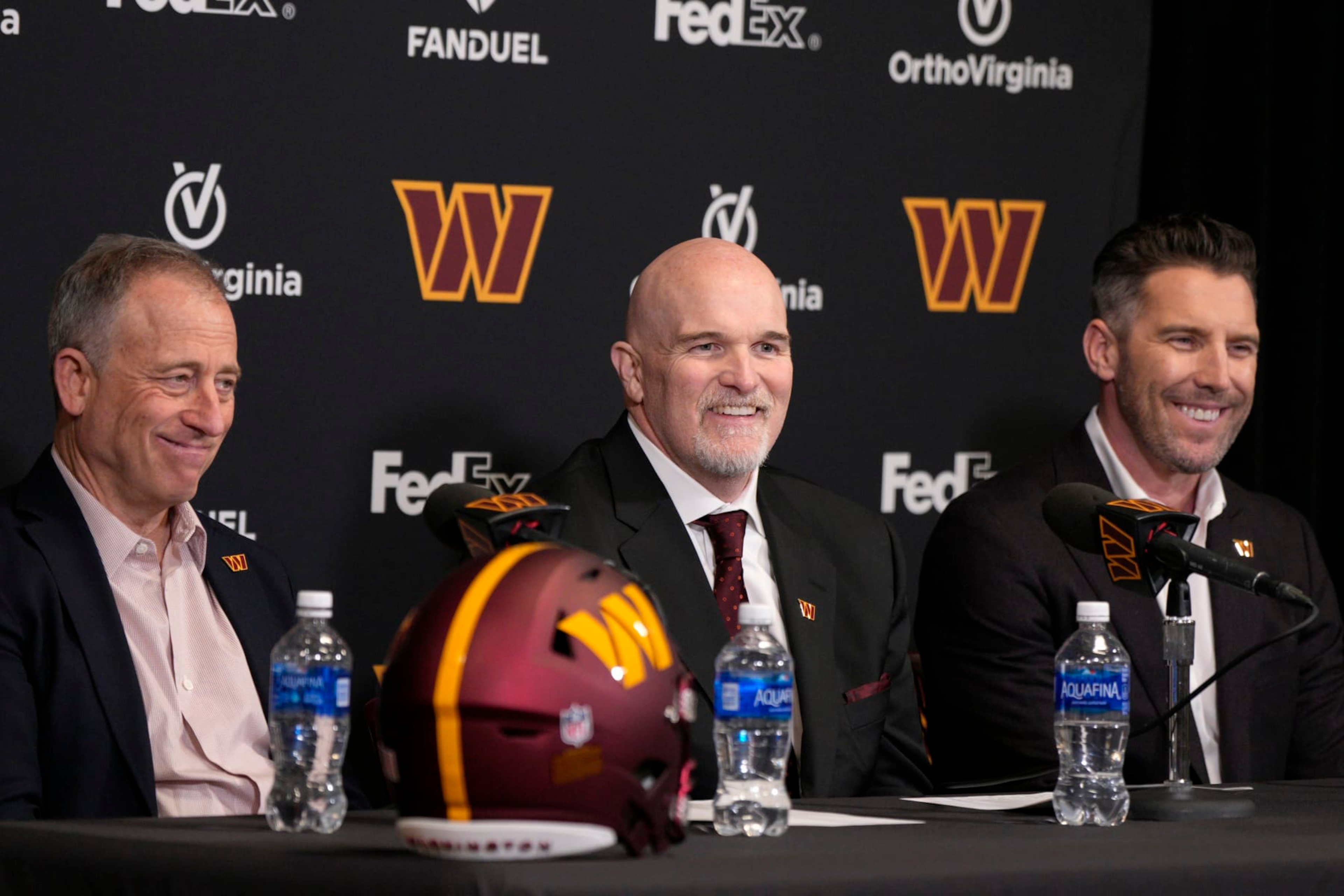ASHBURN, VIRGINIA - FEBRUARY 05: Head coach Dan Quinn of the Washington Commanders speaks during a press conference alongside managing partner Josh Harris, left, and general manager Adam Peters at OrthoVirginia Training Center at Commanders Park on February 05, 2024 in Ashburn, Virginia. (Photo by Jess Rapfogel/Getty Images)