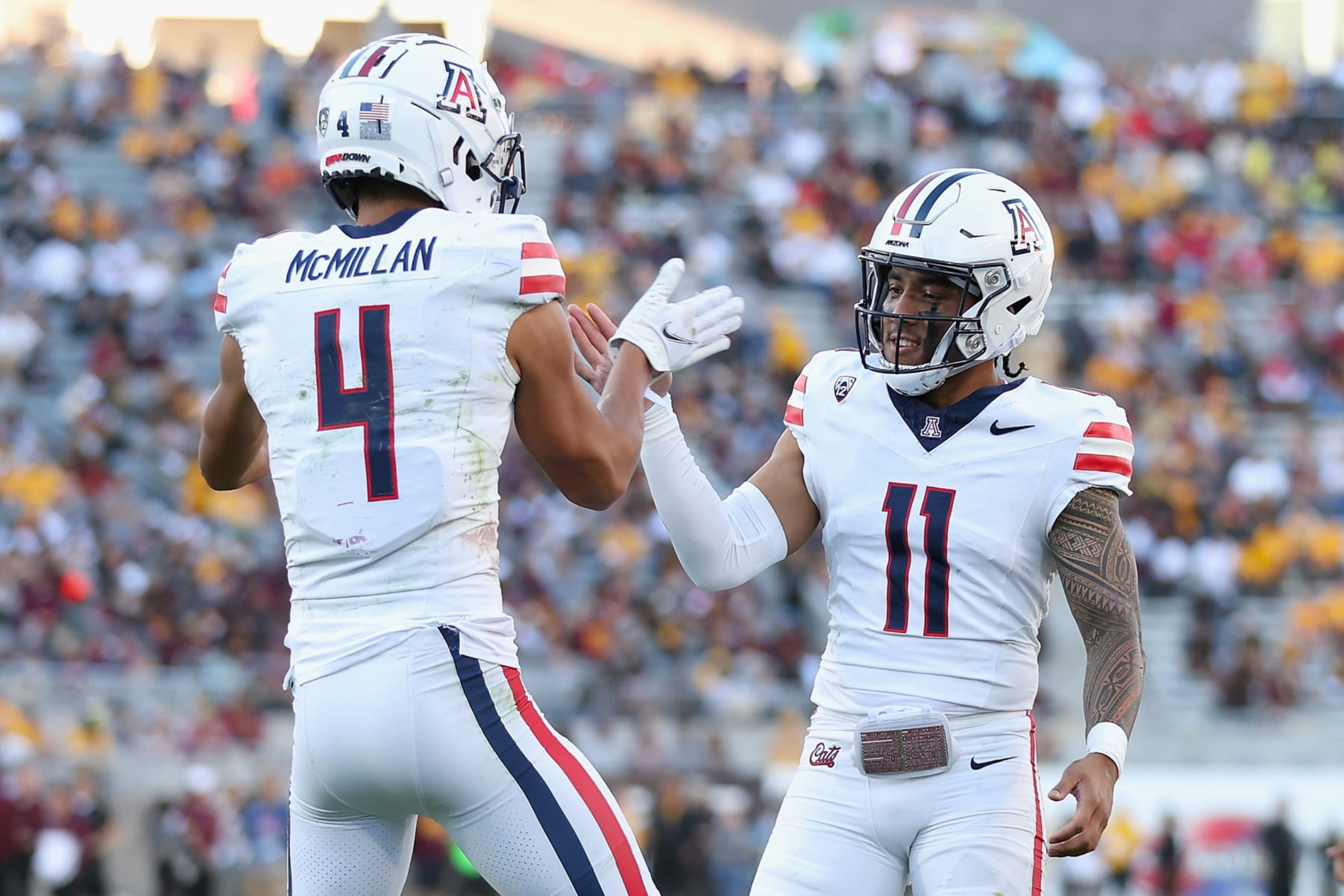 TEMPE, ARIZONA - NOVEMBER 25: Wide receiver Tetairoa McMillan #4 of the Arizona Wildcats celebrates with Noah Fifita #11 after catching a 50-yard touchdown reception against the Arizona State Sun Devils during the second half of the NCAAF game at Mountain America Stadium on November 25, 2023 in Tempe, Arizona. (Photo by Christian Petersen/Getty Images) TEMPE, ARIZONA - NOVEMBER 25: Wide receiver Tetairoa McMillan #4 of the Arizona Wildcats celebrates with Noah Fifita #11 after catching a 50-yard touchdown reception against the Arizona State Sun Devils during the second half of the NCAAF game at Mountain America Stadium on November 25, 2023 in Tempe, Arizona. (Photo by Christian Petersen/Getty Images)