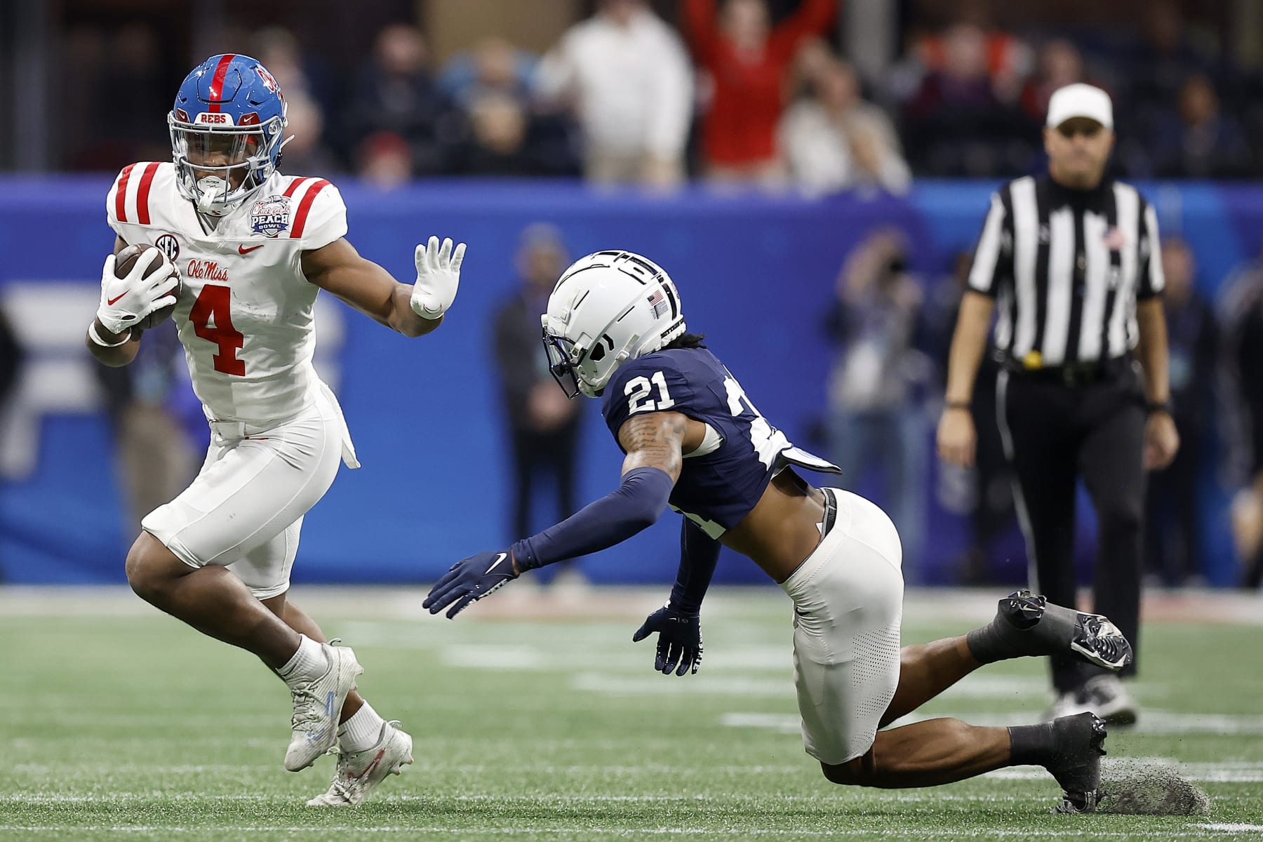 ATLANTA, GEORGIA - DECEMBER 30: Quinshon Judkins #4 of the Mississippi Rebels carries the ball against Kevin Winston Jr. #21 of the Penn State Nittany Lions during the second quarter in the Chick-fil-A Peach Bowl at Mercedes-Benz Stadium on December 30, 2023 in Atlanta, Georgia. (Photo by Alex Slitz/Getty Images)