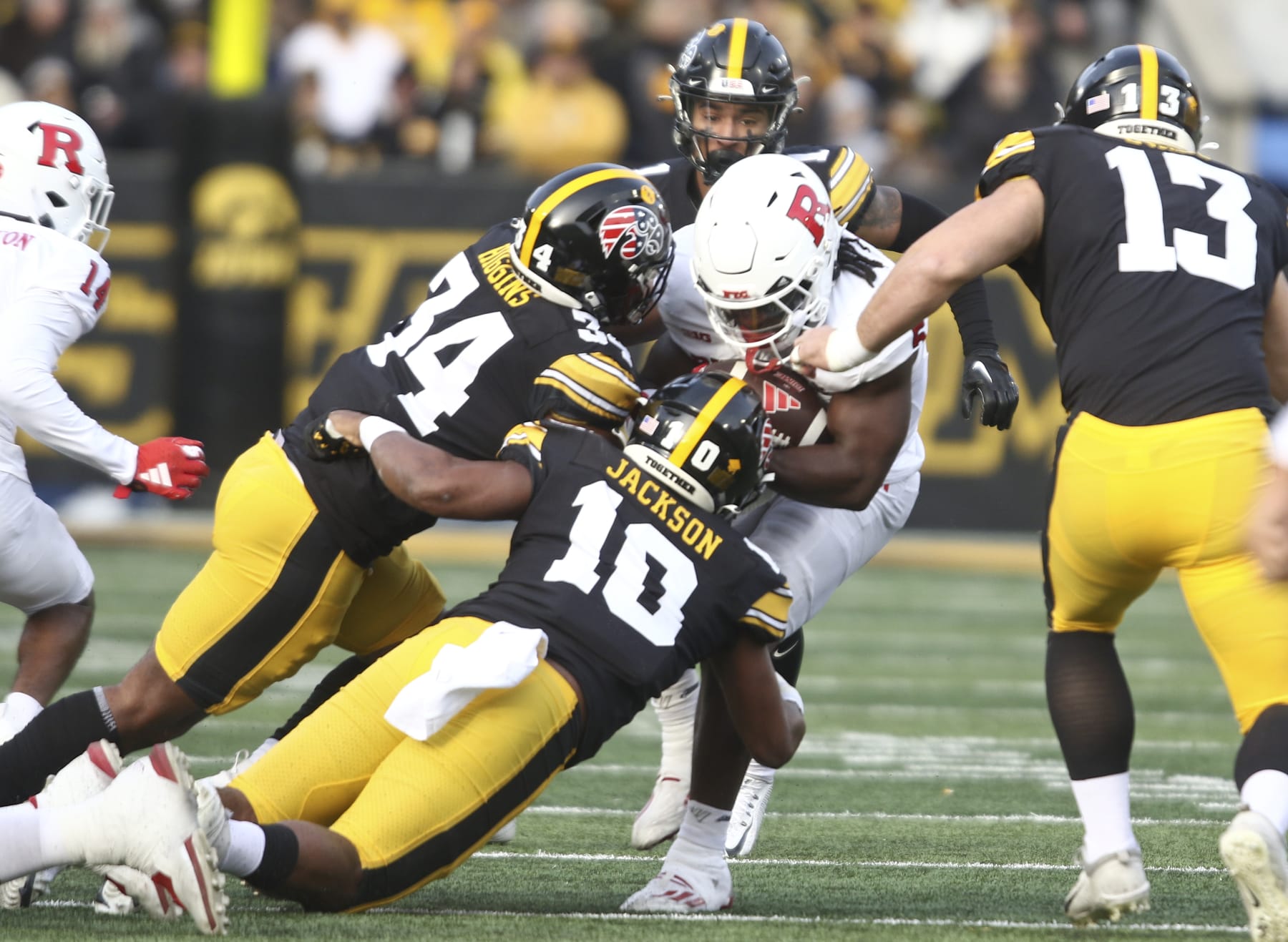 IOWA CITY, IOWA- NOVEMBER 11:  Running back Kyle Monangai #5 of the Rutgers Scarlet Knights goes up the field during the first half against linebacker Jay Higgins #34 and linebacker Nick Jackson #10 of the Iowa Hawkeyes at Kinnick Stadium on November 11, 2023 in Iowa City, Iowa.  (Photo by Matthew Holst/Getty Images)