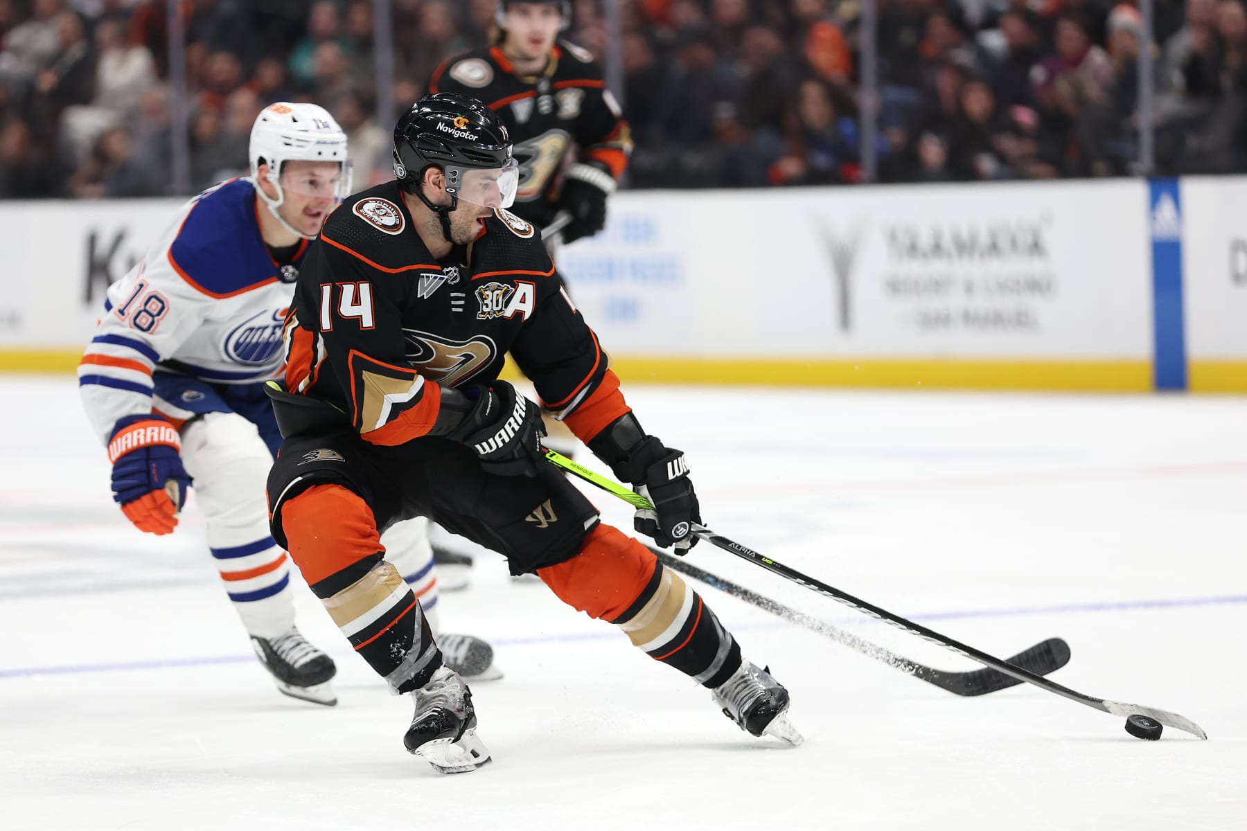 ANAHEIM, CALIFORNIA - FEBRUARY 09: Adam Henrique #14 of the Anaheim Ducks controls the puck past the defense of Zach Hyman #18 of the Edmonton Oilers during the third period of a game at Honda Center on February 09, 2024 in Anaheim, California. (Photo by Sean M. Haffey/Getty Images)