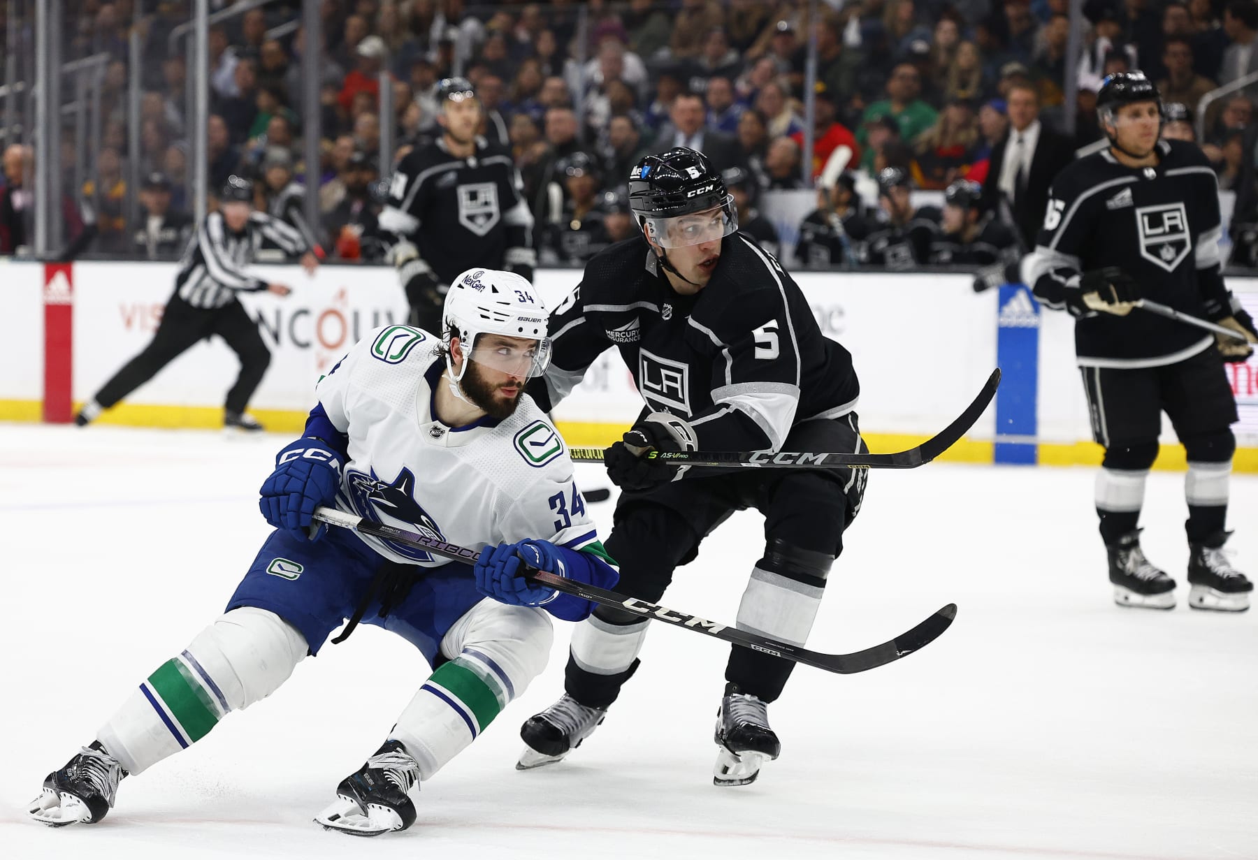 LOS ANGELES, CALIFORNIA - MARCH 05:  Phillip Di Giuseppe #34 of the Vancouver Canucks and Andreas Englund #5 of the Los Angeles Kings at Crypto.com Arena on March 05, 2024 in Los Angeles, California. (Photo by Ronald Martinez/Getty Images)