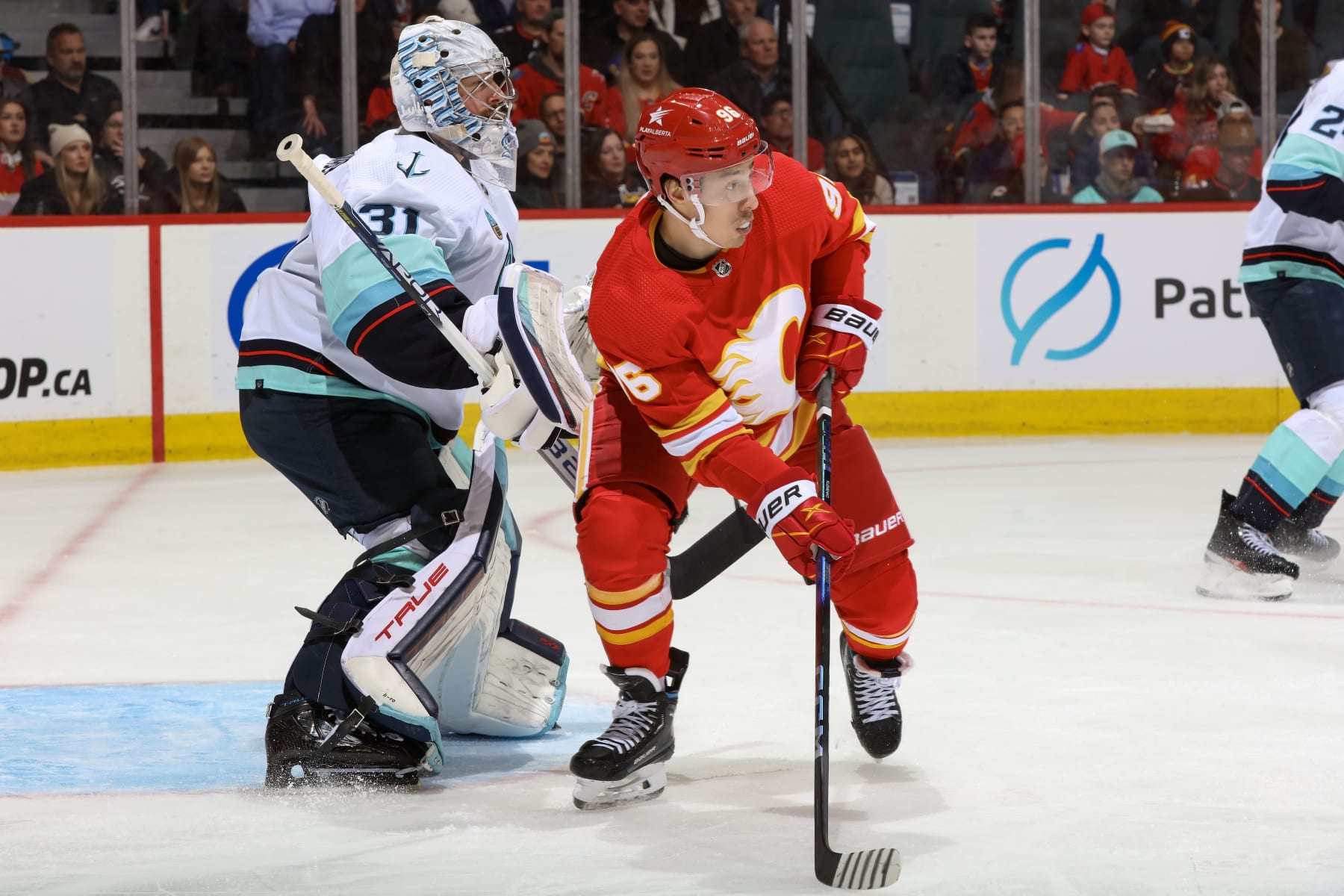 CALGARY, AB - MARCH 4: Andrei Kuzmenko #96 of the Calgary Flames screens Philipp Grubauer #31 of the Seattle Kraken at Scotiabank Saddledome on March 4, 2024 in Calgary, Alberta, Canada. (Photo by Gerry Thomas/NHLI via Getty Images)