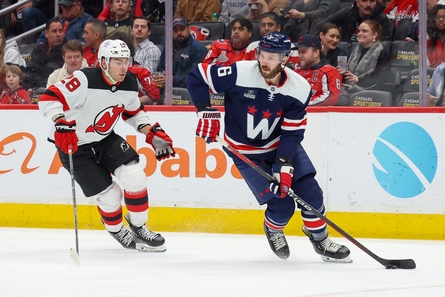 WASHINGTON, DC - FEBRUARY 20: Joel Edmundson #6 of the Washington Capitals protects the puck from a pressuring Timo Meier #28 of the New Jersey Devils during a game at Capital One Arena on February 20, 2024 in Washington, D.C. (Photo by John McCreary/NHLI via Getty Images)