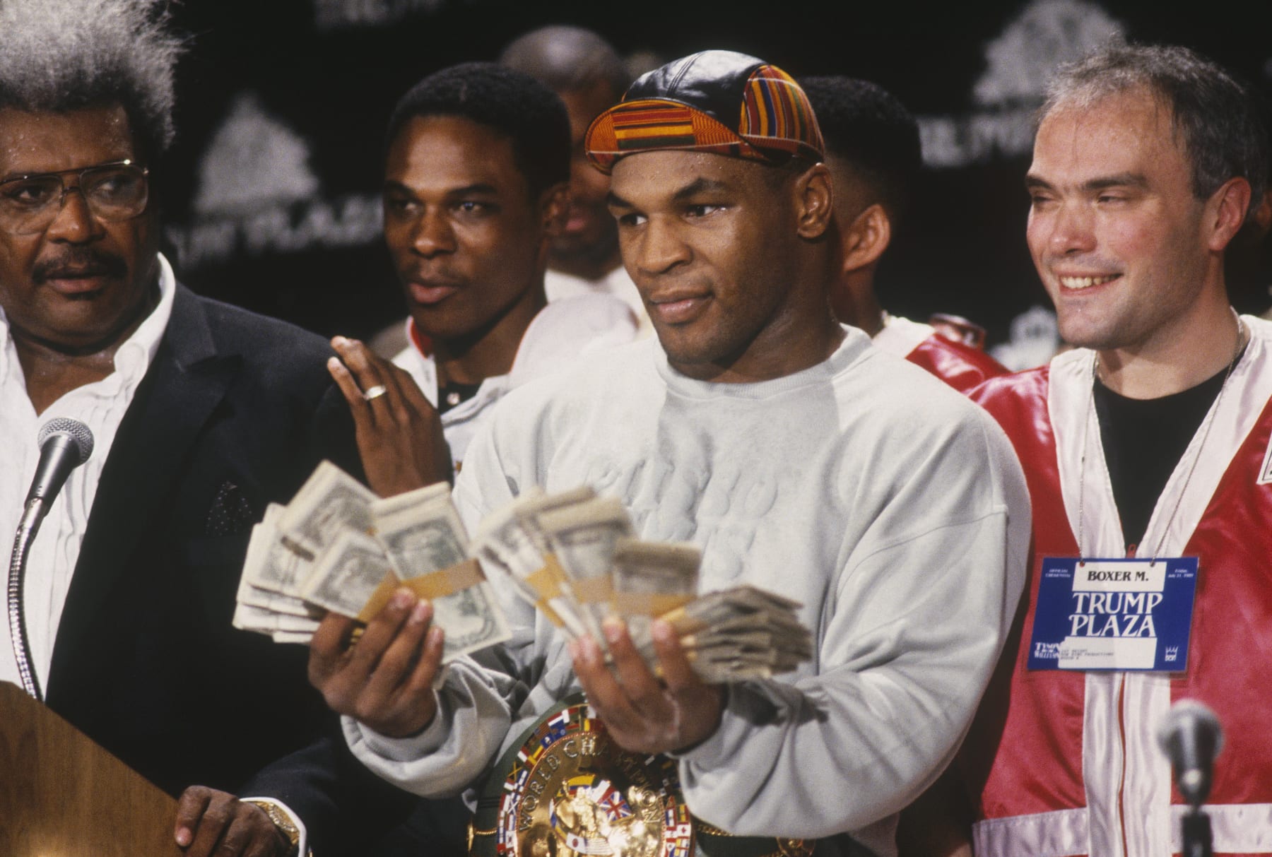 UNDATED: Mike Tyson holds two fists full of money and poses for cameras next to Don King during a press conference. (Photo by Focus on Sport/Gettty Images)