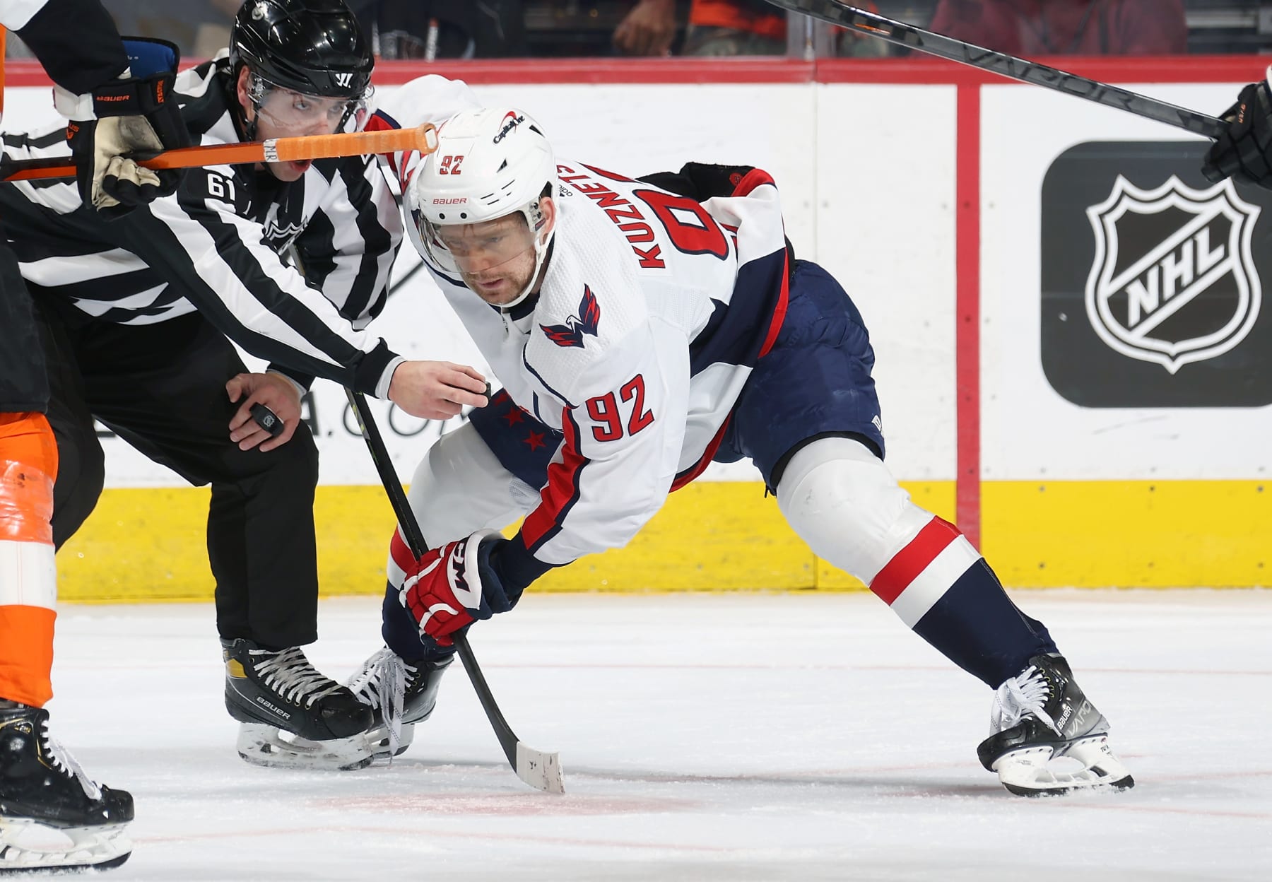 PHILADELPHIA, PENNSYLVANIA - JANUARY 11:  Linesman James Tobias #61 prepares to drop the puck on a face-off between Evgeni Kuznetsov #92 of the Washington Capitals and a member of the Philadelphia Flyers at the Wells Fargo Center on January 11, 2023 in Philadelphia, Pennsylvania.  (Photo by Len Redkoles/NHLI via Getty Images)
