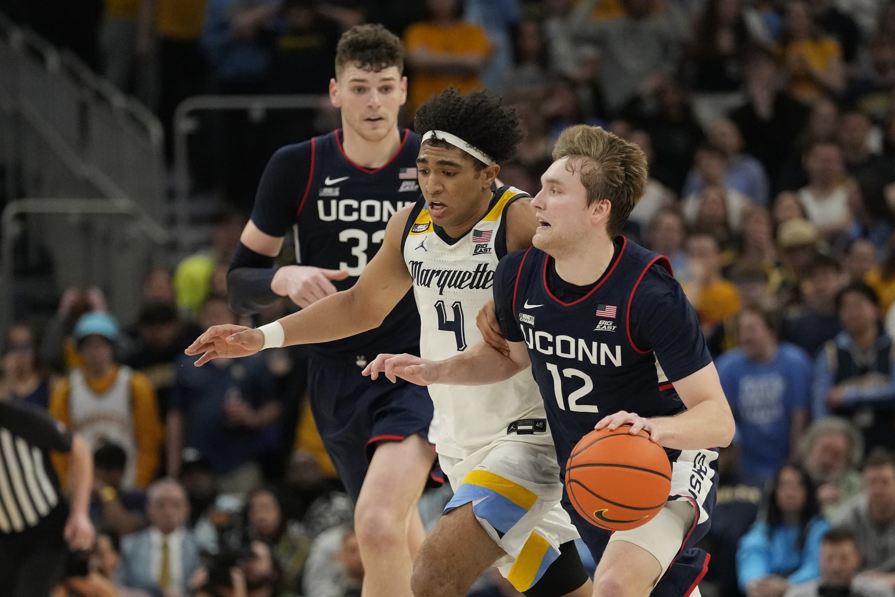 MILWAUKEE, WISCONSIN - MARCH 06: Cam Spencer #12 of the Connecticut Huskies dribbles the ball against Stevie Mitchell #4 of the Marquette Golden Eagles during the second half at Fiserv Forum on March 06, 2024 in Milwaukee, Wisconsin. (Photo by Patrick McDermott/Getty Images)