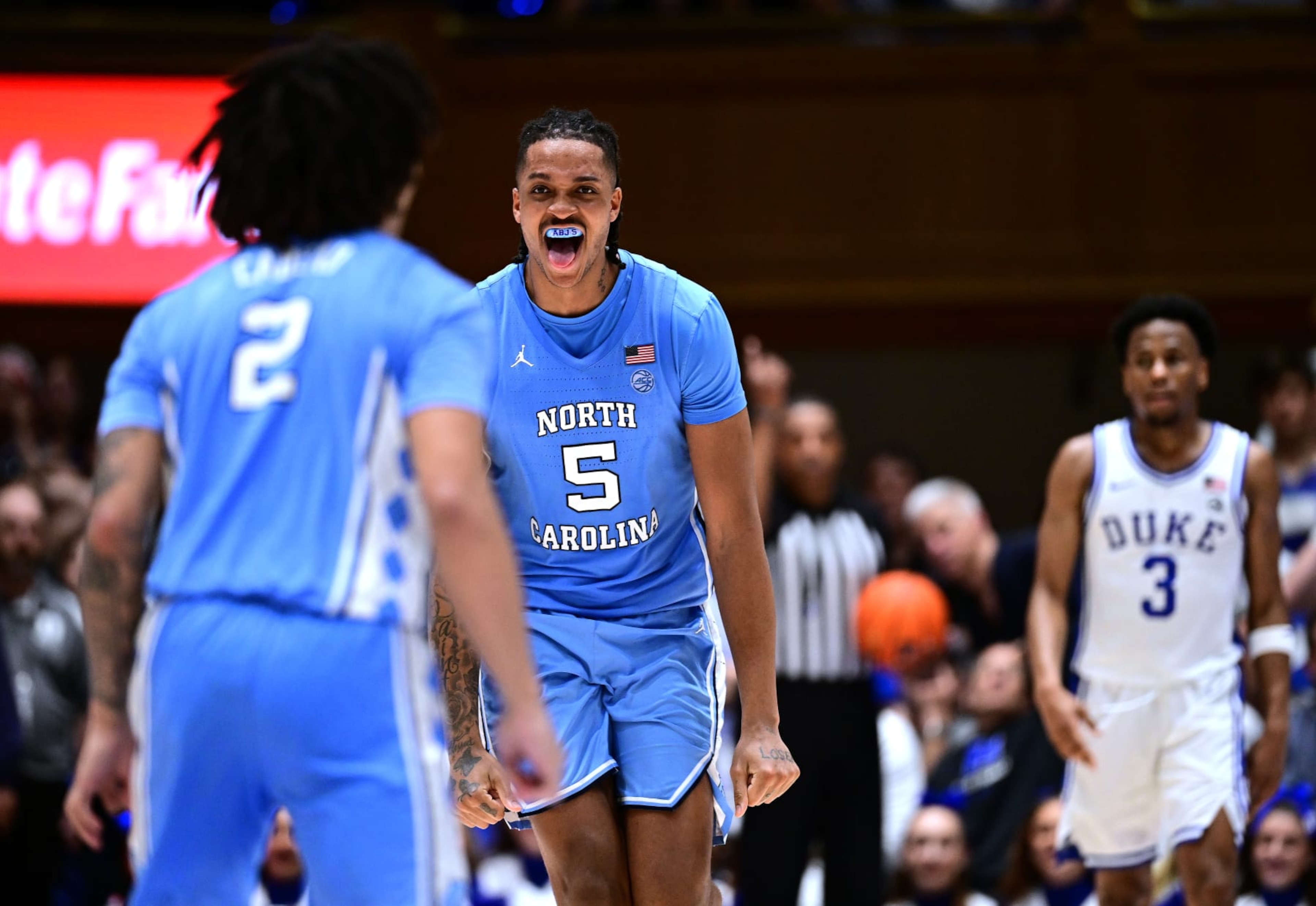 DURHAM, NORTH CAROLINA - MARCH 09: Elliot Cadeau #2 and Armando Bacot #5 of the North Carolina Tar Heels celebrate in front of Jeremy Roach #3 of the Duke Blue Devils during the final seconds of a win at Cameron Indoor Stadium on March 09, 2024 in Durham, North Carolina.The Tar Heels won 84-79. (Photo by Grant Halverson/Getty Images) DURHAM, NORTH CAROLINA - MARCH 09: Elliot Cadeau #2 and Armando Bacot #5 of the North Carolina Tar Heels celebrate in front of Jeremy Roach #3 of the Duke Blue Devils during the final seconds of a win at Cameron Indoor Stadium on March 09, 2024 in Durham, North Carolina.The Tar Heels won 84-79. (Photo by Grant Halverson/Getty Images)
