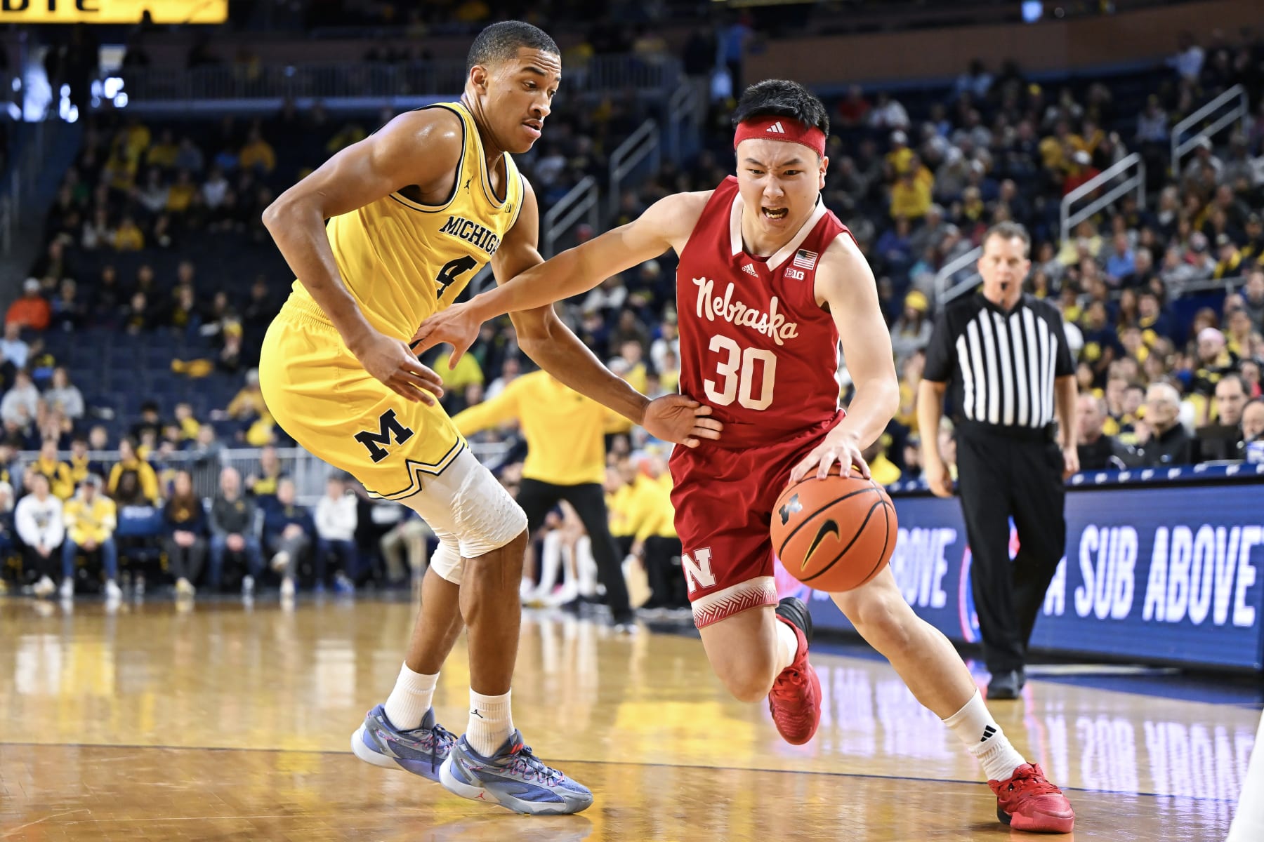 ANN ARBOR, MICHIGAN - MARCH 10: Keisei Tominaga #30 of the Nebraska Cornhuskers dribbles the ball against Nimari Burnett #4 of the Michigan Wolverines during the second half at Crisler Arena on March 10, 2024 in Ann Arbor, Michigan. (Photo by Luke Hales/Getty Images)