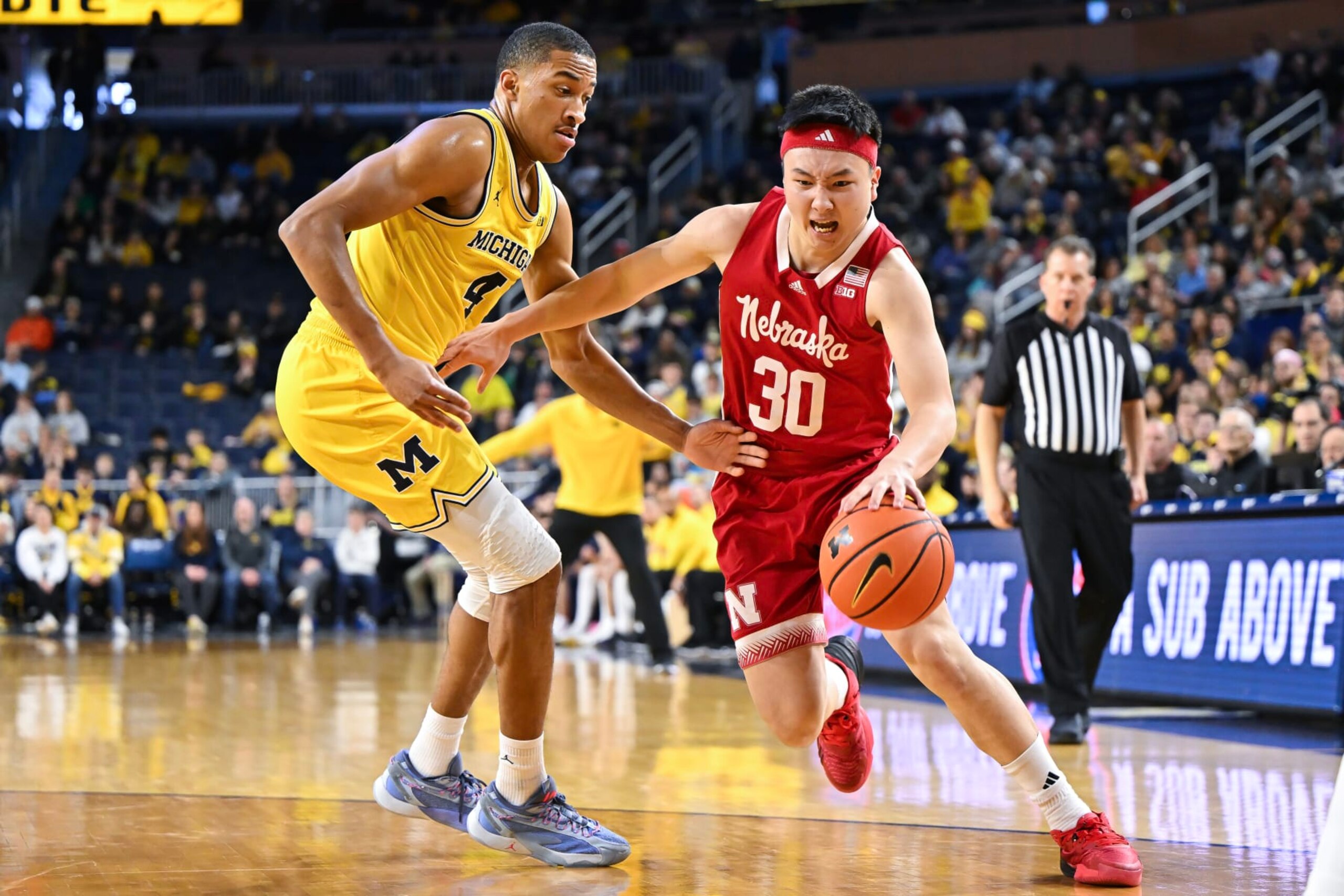 ANN ARBOR, MICHIGAN - MARCH 10: Keisei Tominaga #30 of the Nebraska Cornhuskers dribbles the ball against Nimari Burnett #4 of the Michigan Wolverines during the second half at Crisler Arena on March 10, 2024 in Ann Arbor, Michigan. (Photo by Luke Hales/Getty Images)